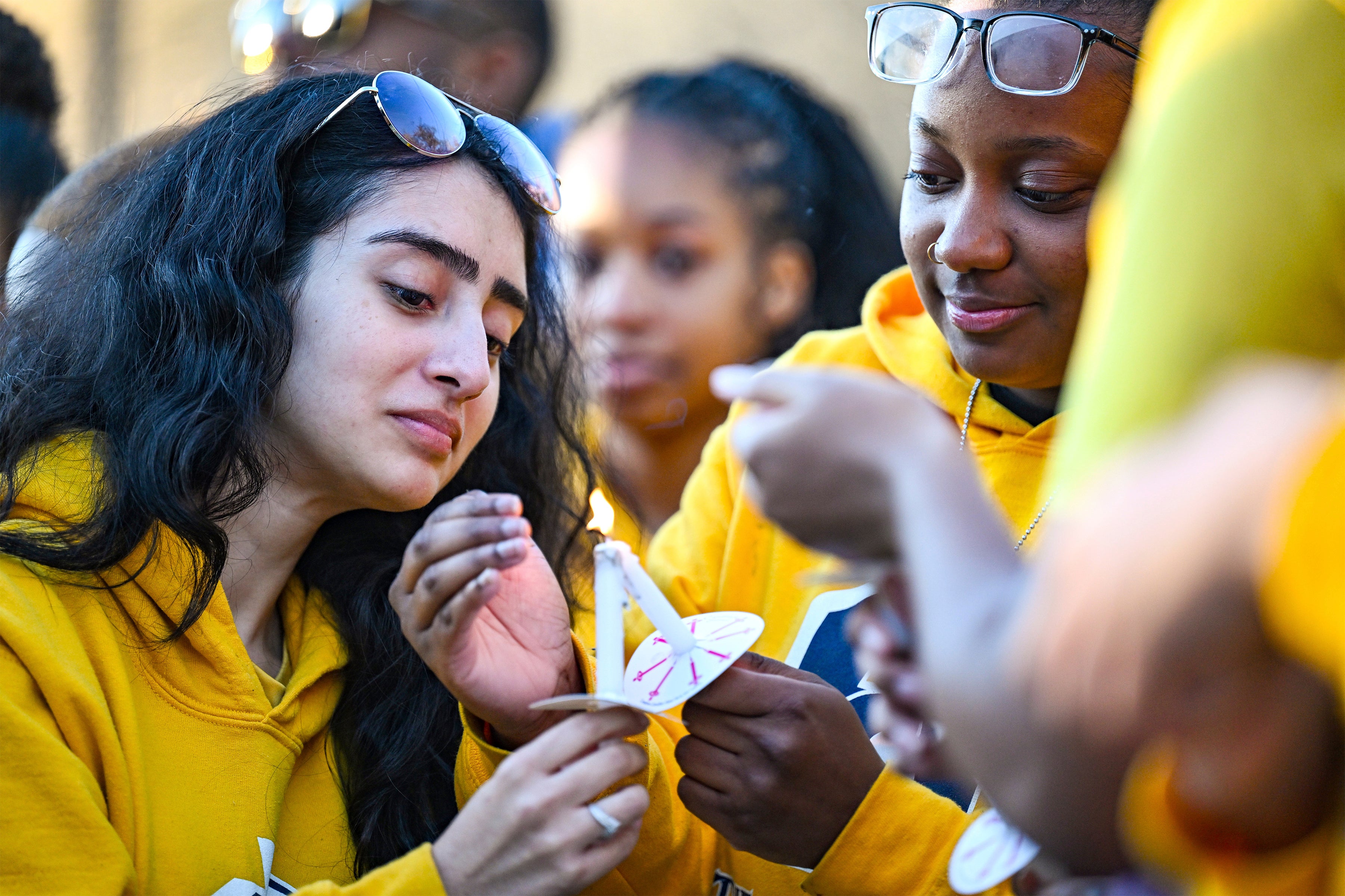 Jaylen Lewis, right, helps light Virginia Olide's candle during a vigil for Caleb Wilson at Southern University