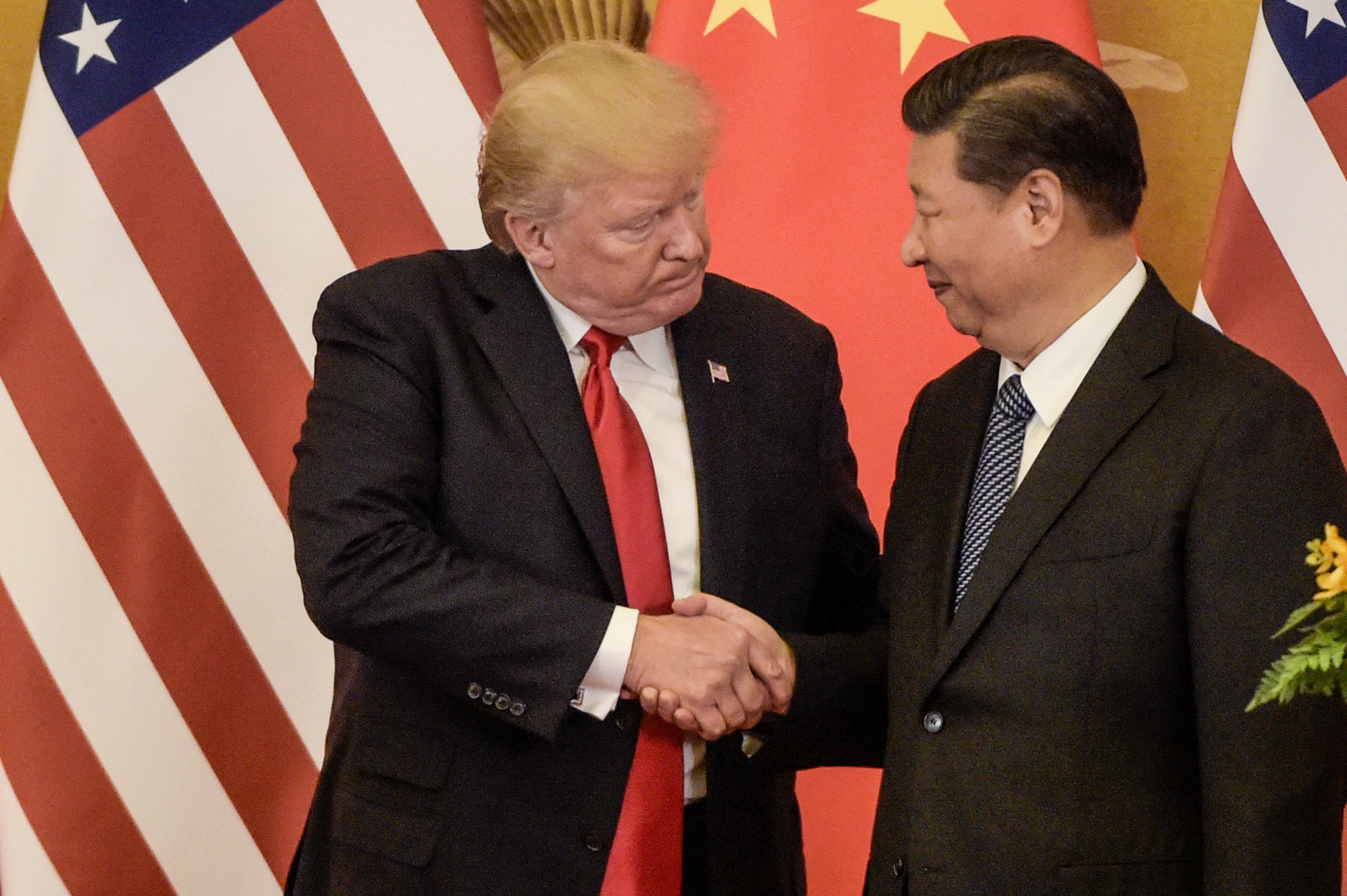 File: US President Donald Trump (L) shakes hand with China's President Xi Jinping at the end of a press conference at the Great Hall of the People in Beijing on November 9, 2017
