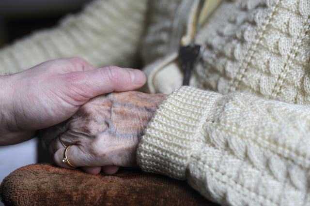 <p>File. A woman suffering from Alzheimer's holds a relative’s hand</p>