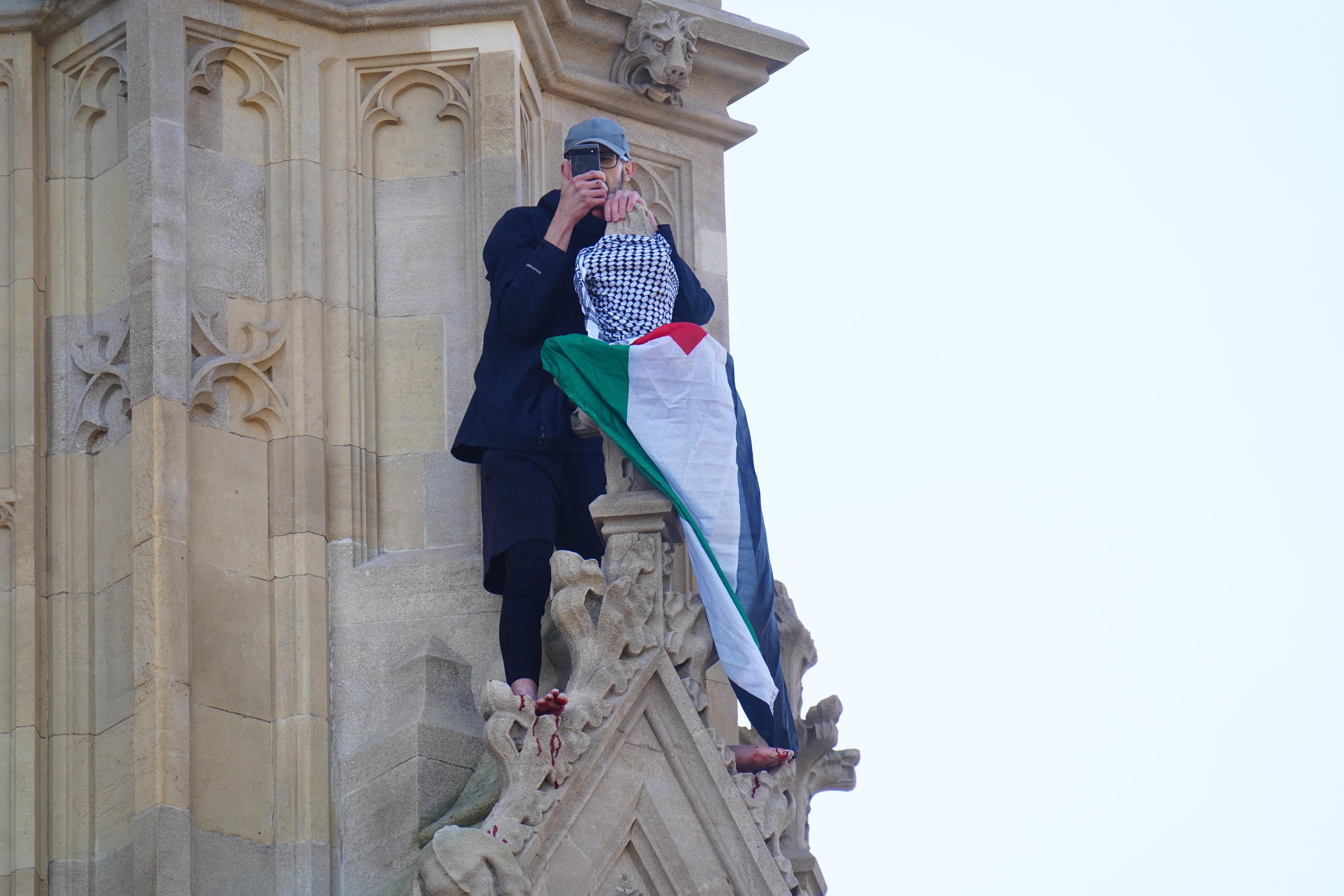 A man with a Palestine flag after he climbed up Elizabeth Tower, which houses Big Ben (James Manning/PA)