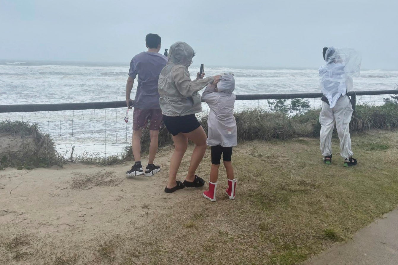 People stand at the beach in high winds