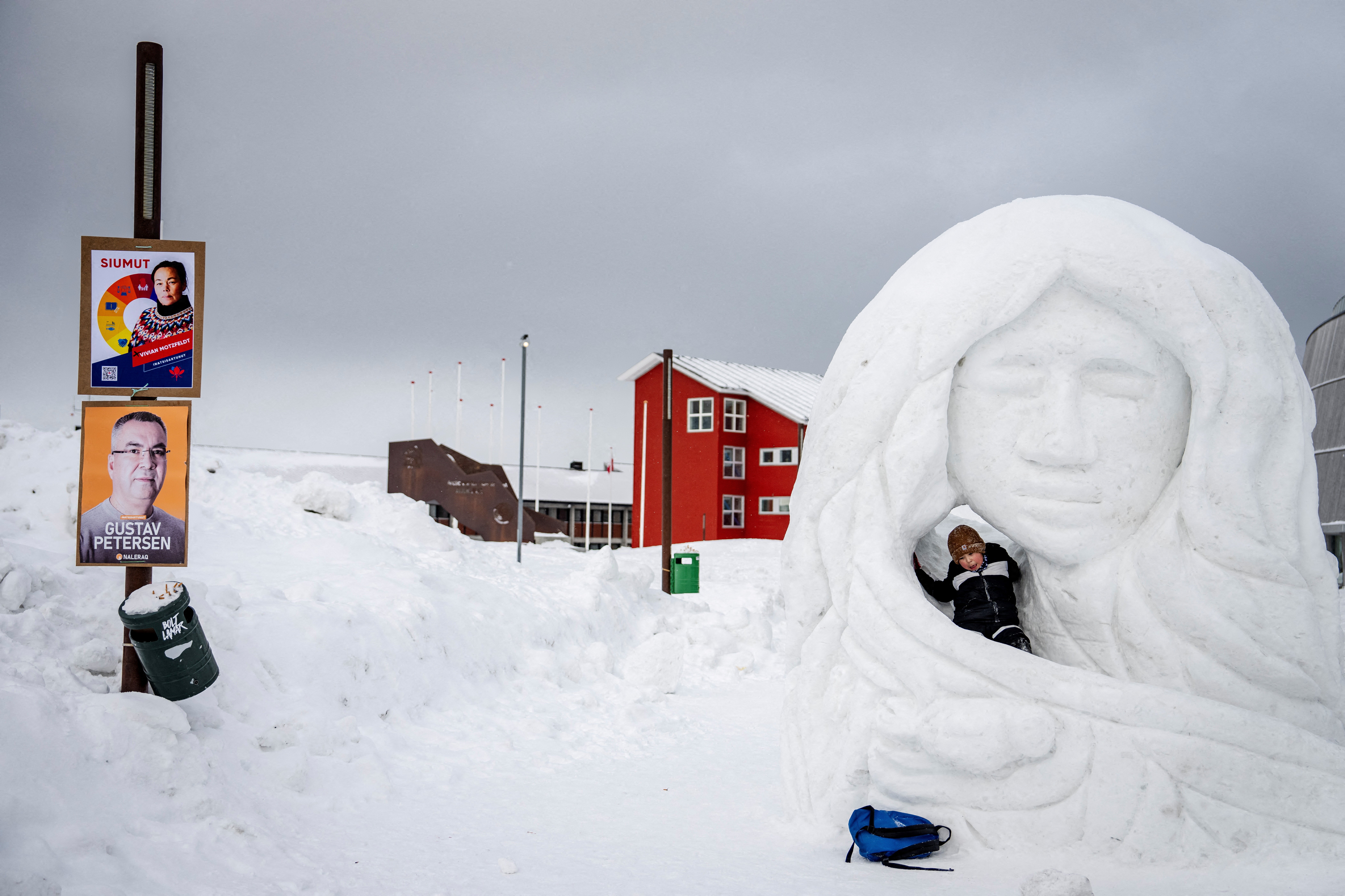 A child plays beside election posters in Nuuk, Greenland