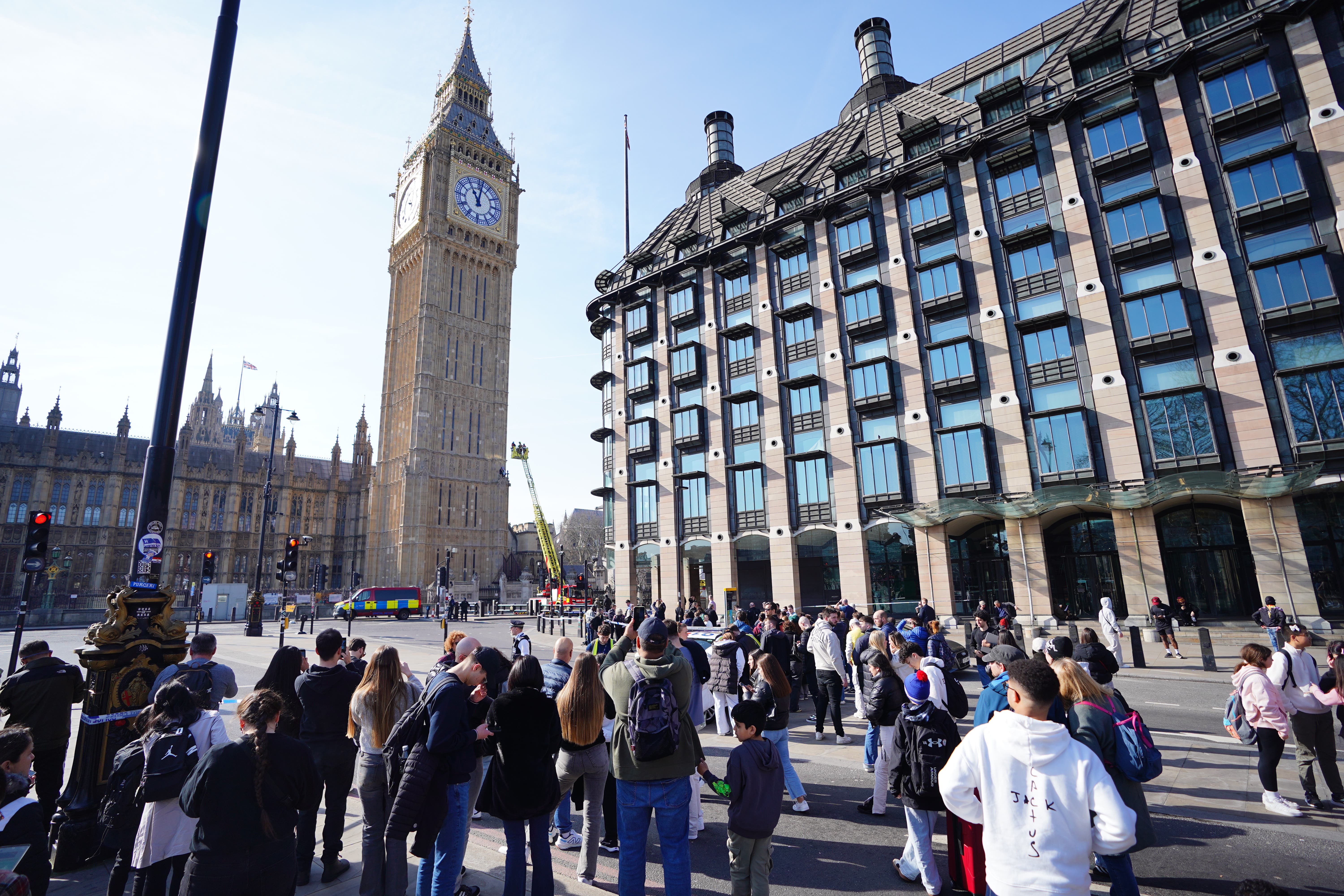 People watch on as the man perched on the clock tower of Big Ben (James Manning/PA)
