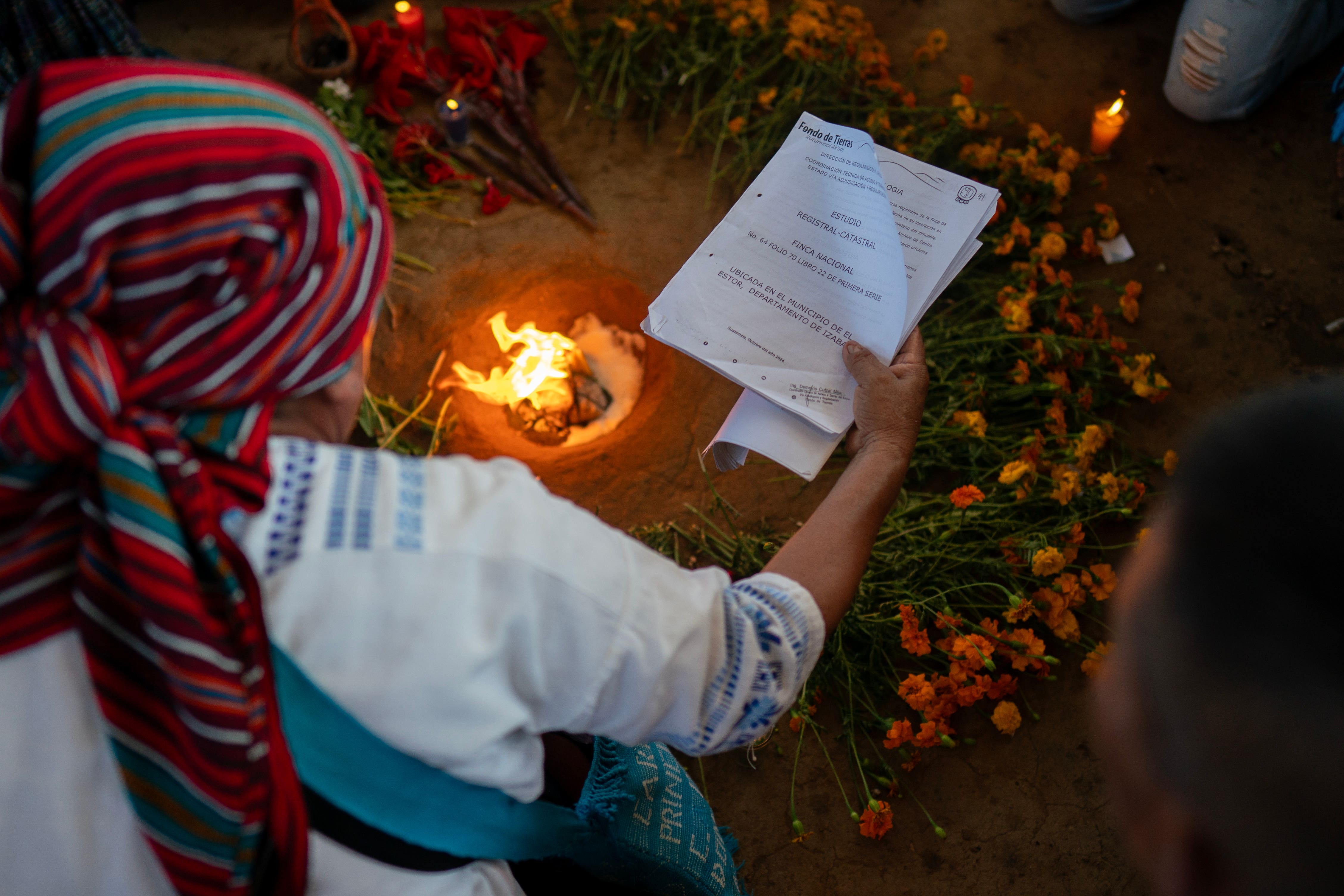 A spiritual leader waves legal documents over a fire during a Mayan-Catholic ceremony in Chinebal Palestina, Guatemala (Brian Lawless/PA)