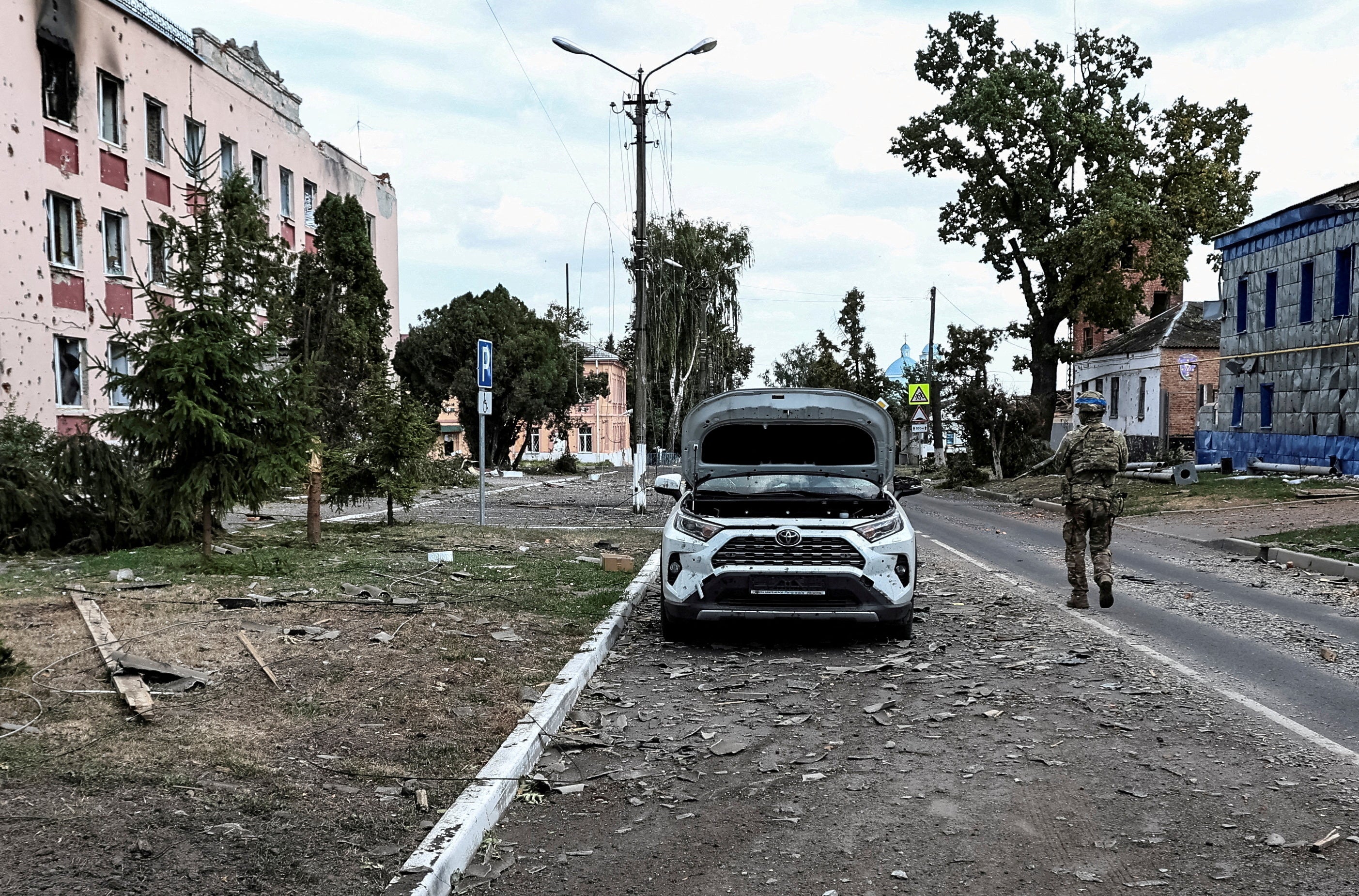 A Ukrainian serviceman patrols a street in Sudzha in 2024