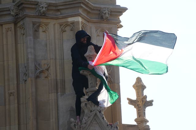 A man holds a Palestinian flag after he climbed up Elizabeth Tower, which houses Big Ben at the Palace of Westminster in London. Picture date: Saturday March 8, 2025 (Jeff Moore/PA)