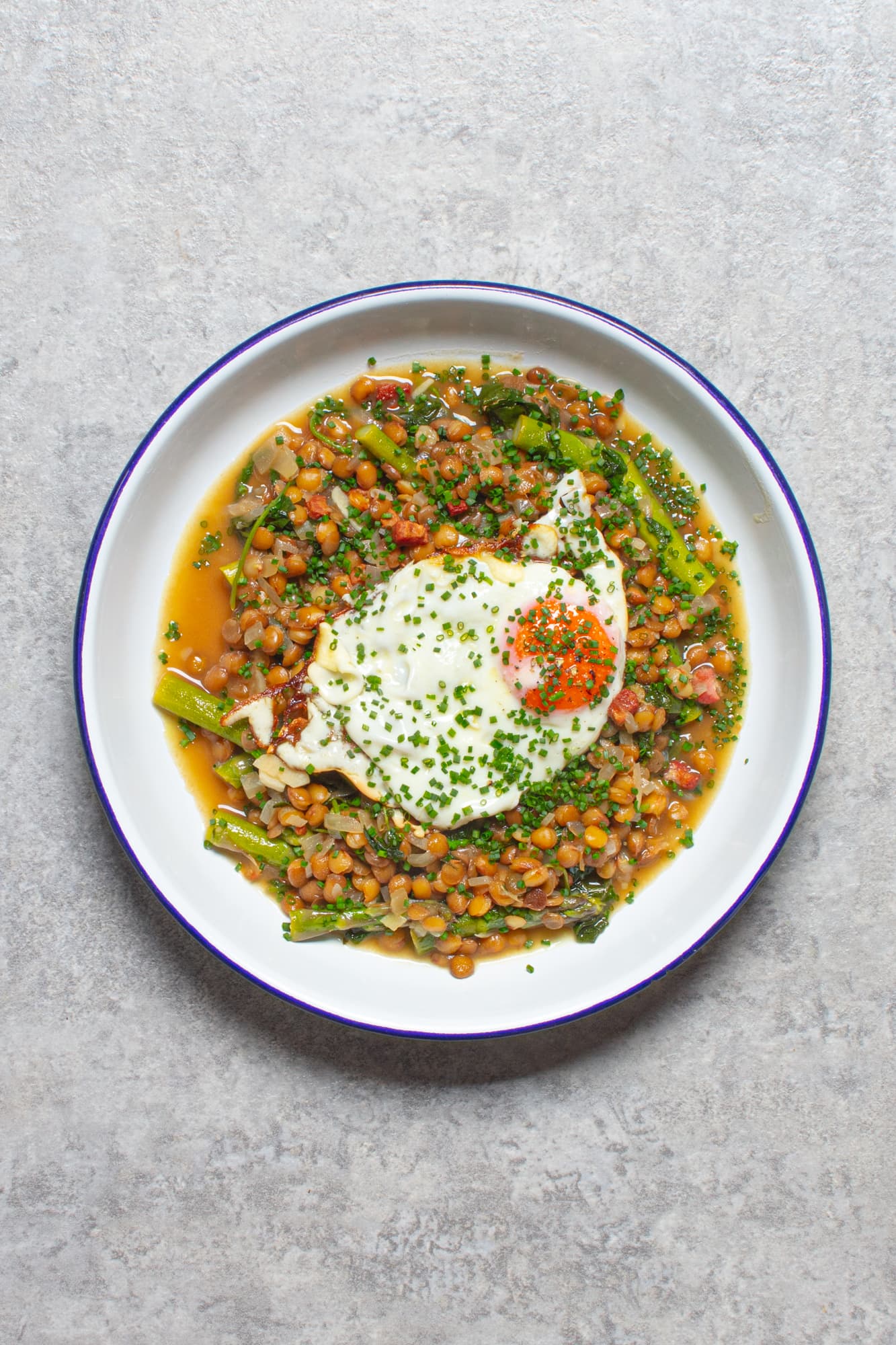 Comfort food, but make it spring – slow-braised lentils with asparagus, pancetta and a crispy fried egg