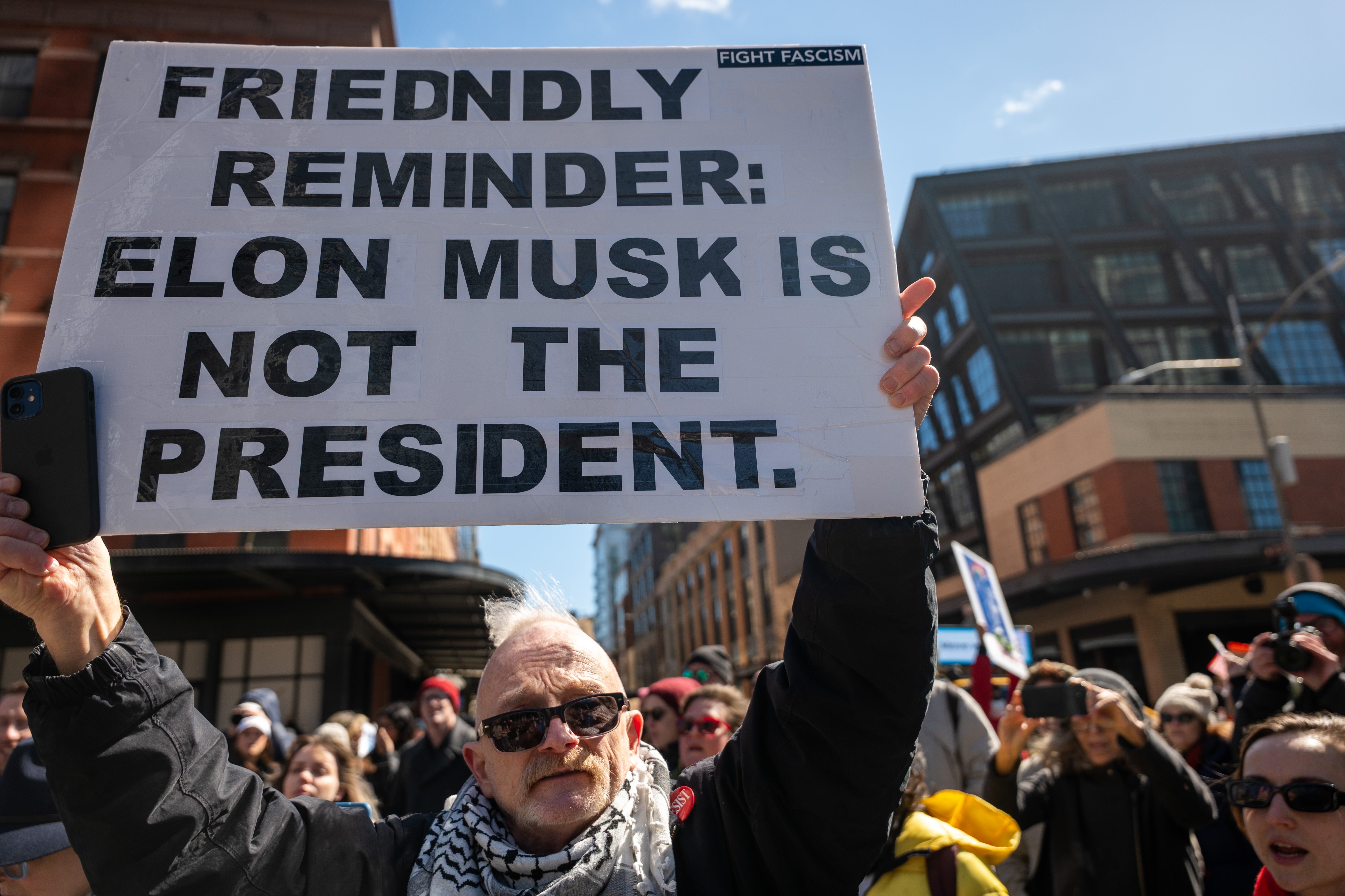 Protesters gather outside a Tesla dealership in Manhattan to demonstrate against Elon Musk on March 8