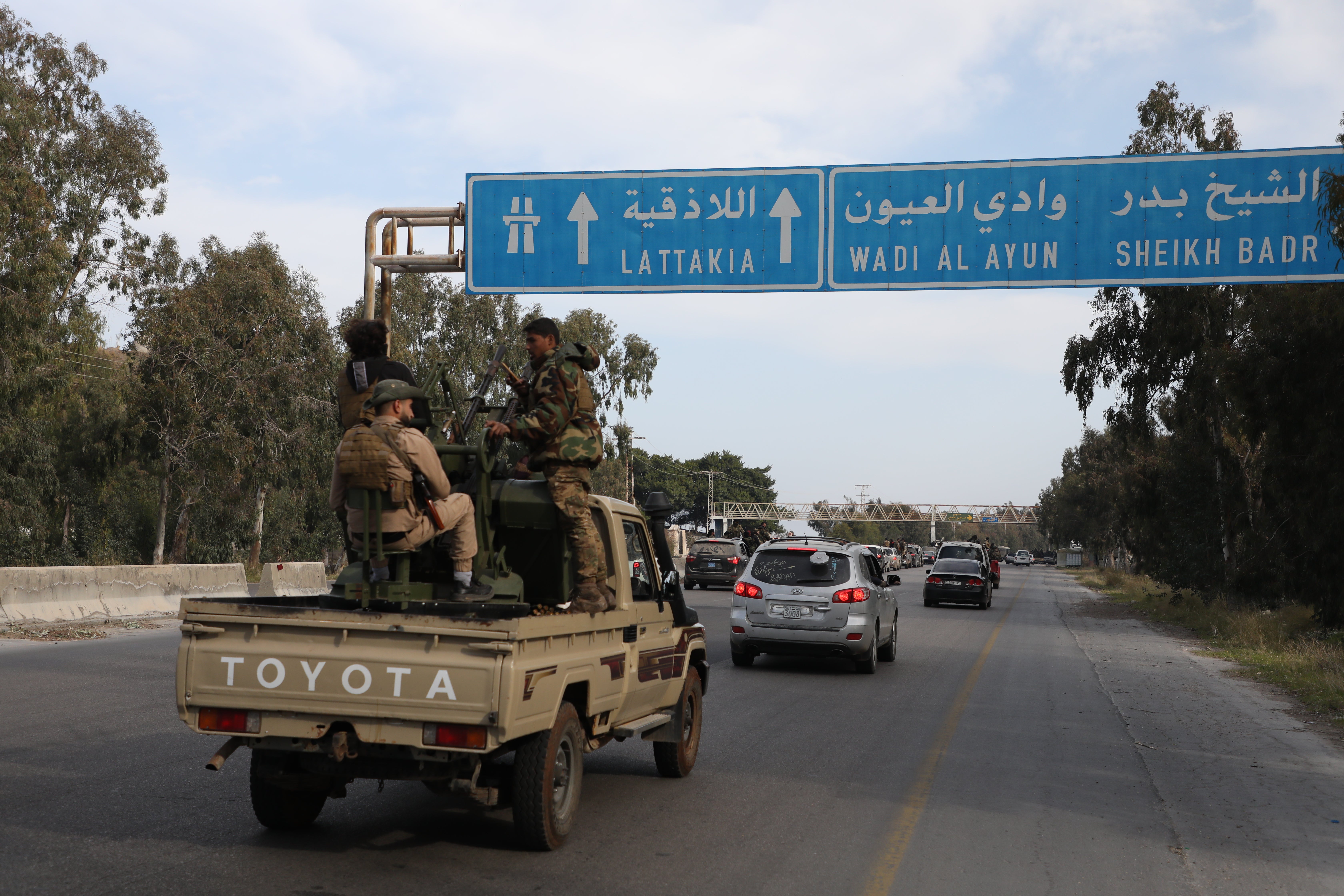Fighters with the new Syrian government drive between Tartus and Latakia