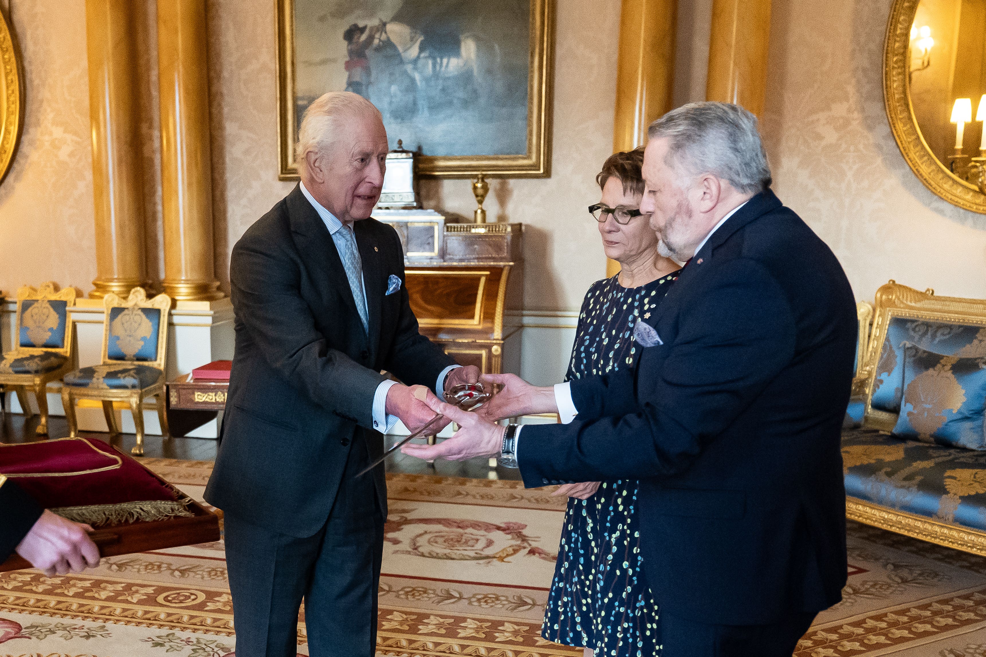 The King bestows a new ceremonial sword to the Usher of the Black Rod of the Senate of Canada Gregory Peters with Speaker of the Senate of Canada Raymonde Gagne (Aaron Chown/PA)