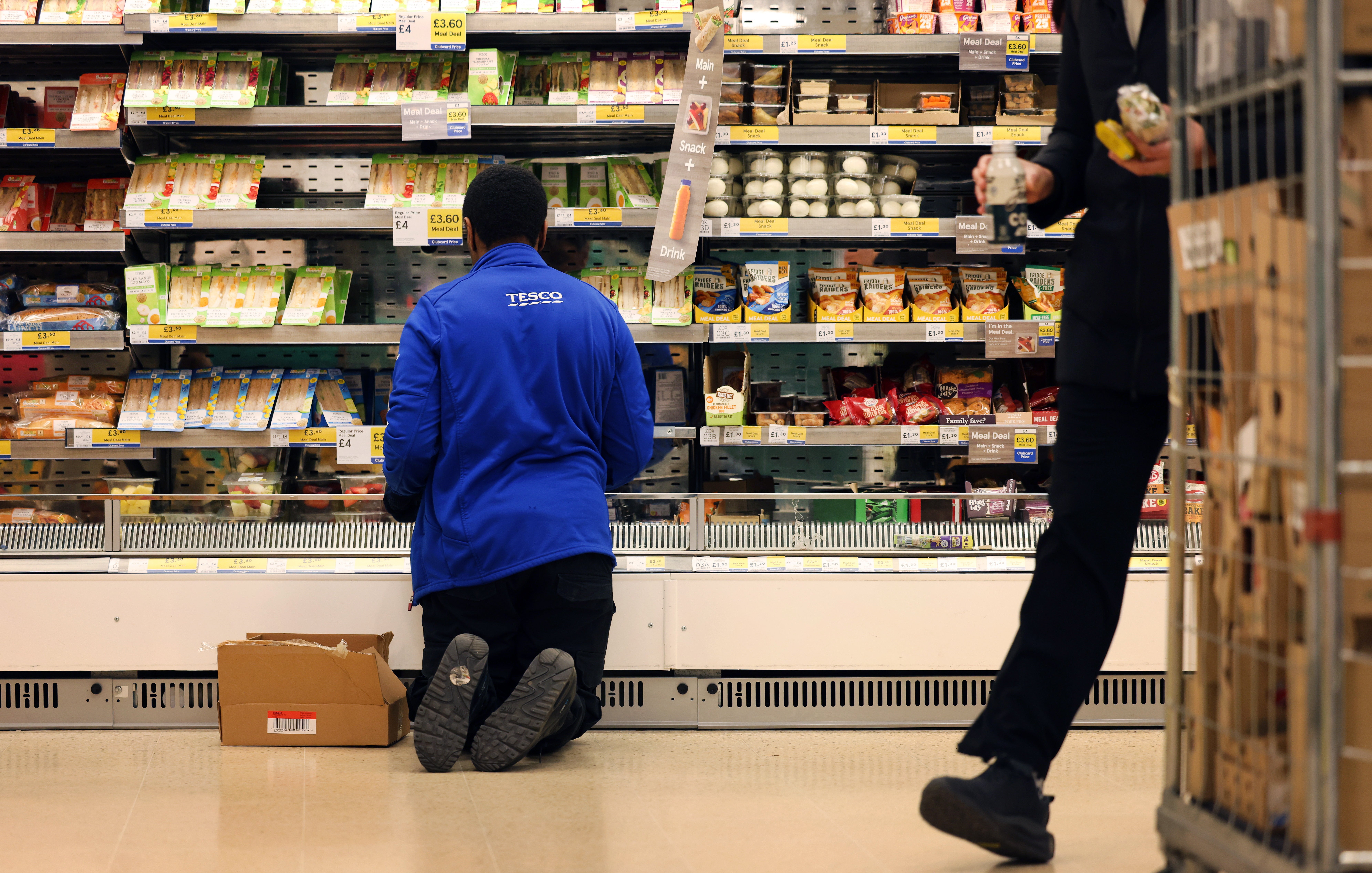 Man shopping in a supermarket while on a budget. He is looking for low prices due to inflation. He is living in the North East of England.