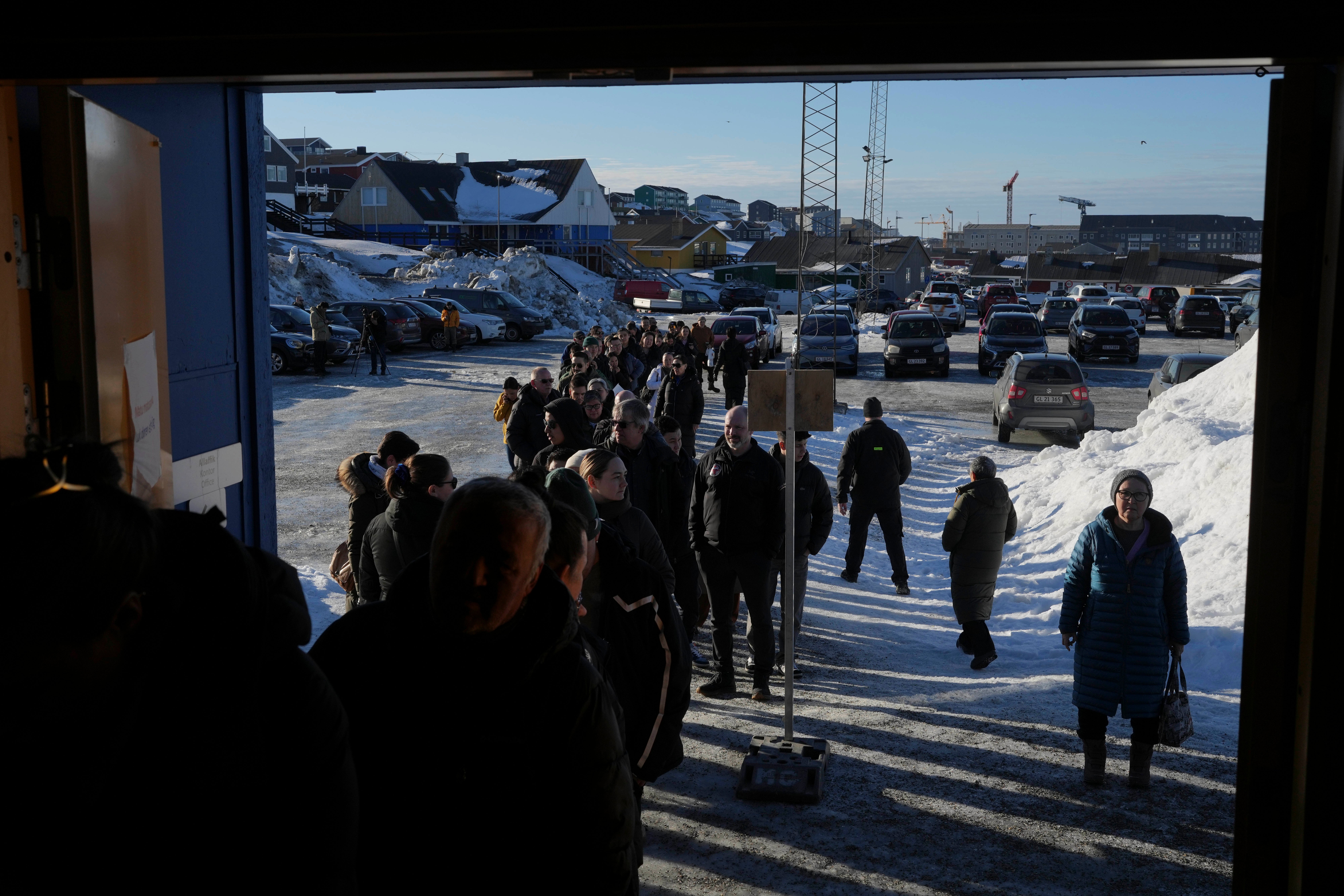 People line up outside a polling station to cast their vote in parliamentary elections in Greenland
