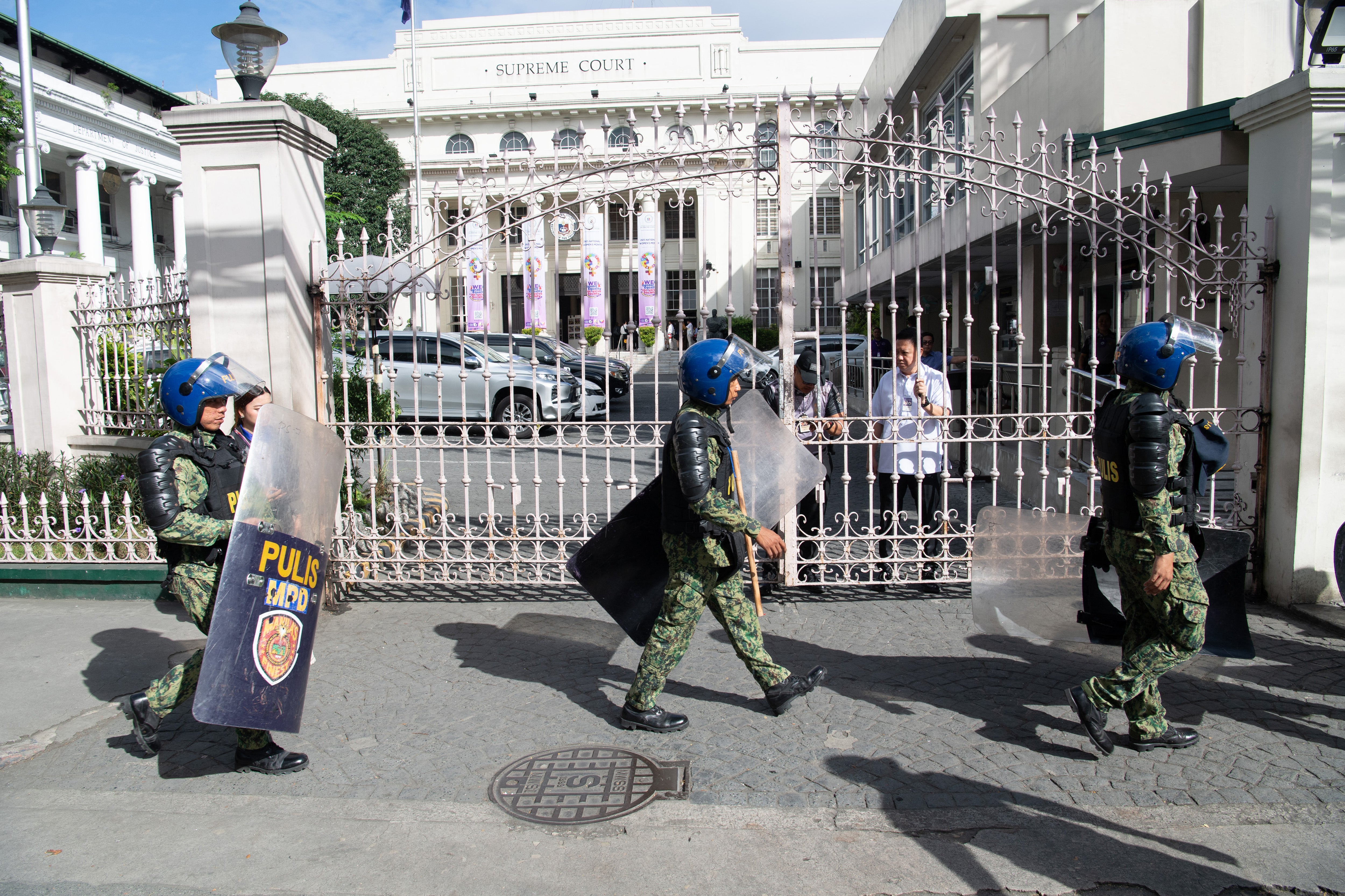Philippine policemen walk past the Supreme Court on 12 March 2025 as security is heightened in the capital Manila a day after the arrest of former president Rodrigo Duterte