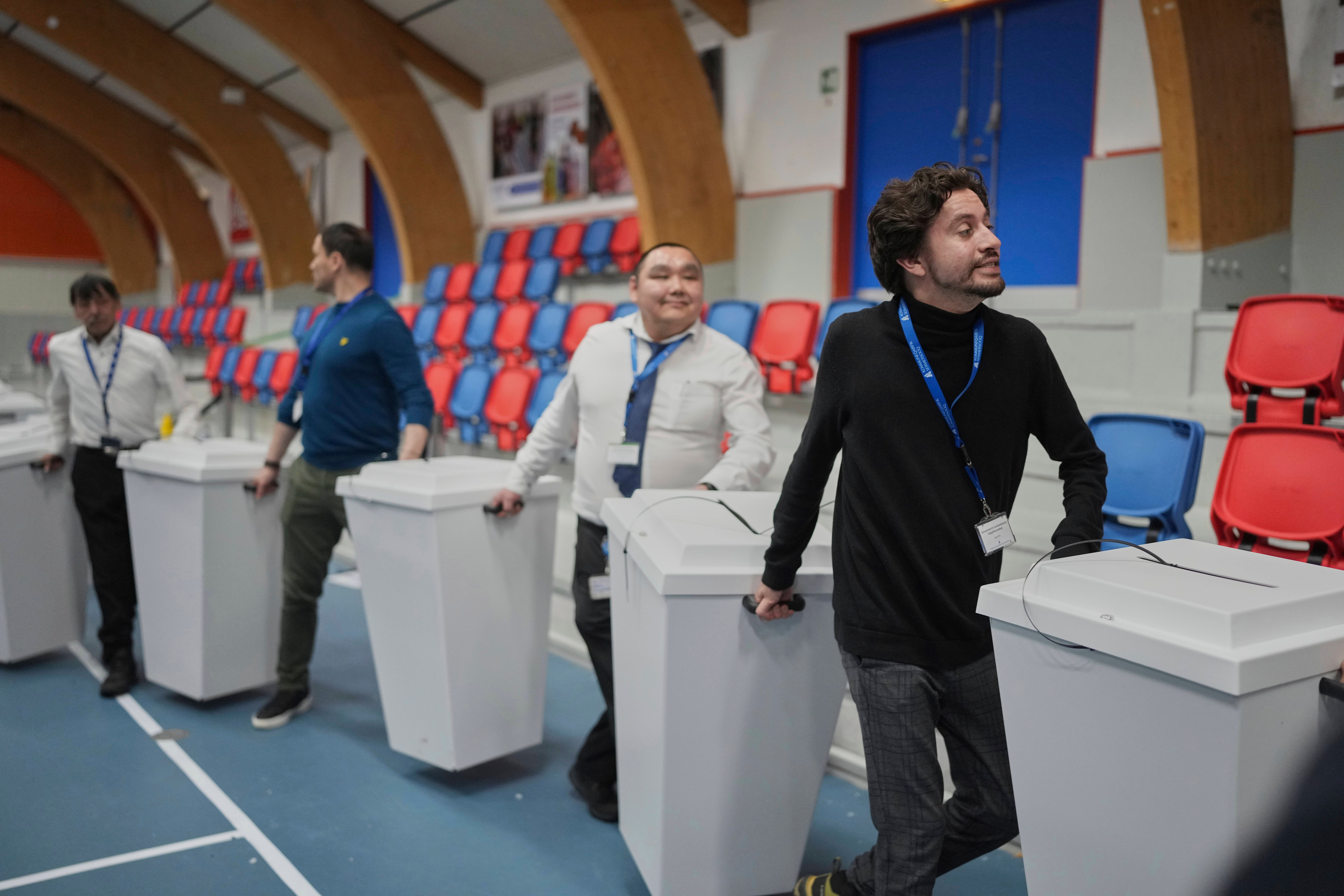 Electoral workers transport ballot boxes to be counted in parliamentary elections in Nuuk, Greenland, Tuesday, 11 March 2025