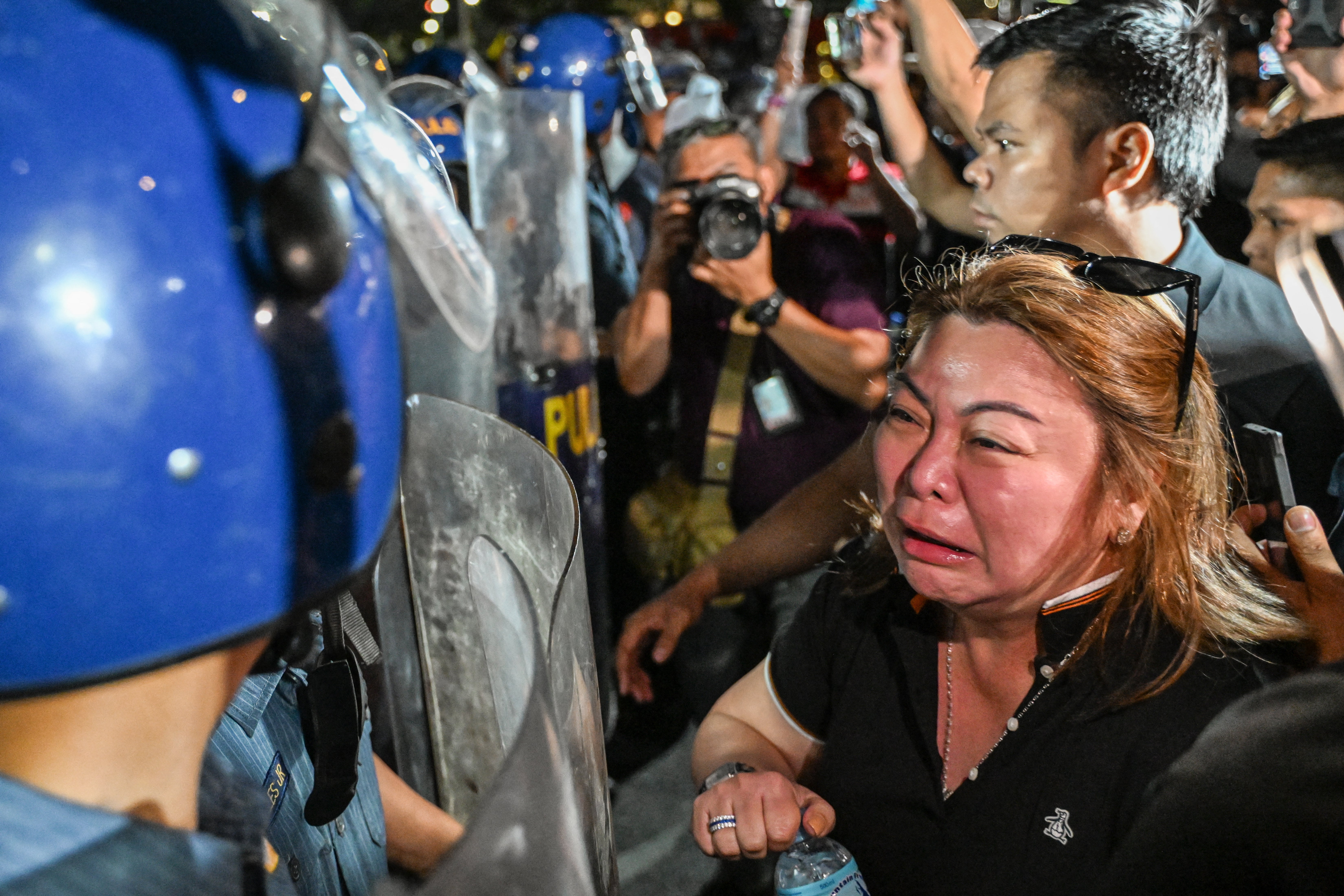 A supporter of former Philippine president Rodrigo Duterte reacts while facing police outside the Villamor Air Base, where he was held for a while in Metro Manila