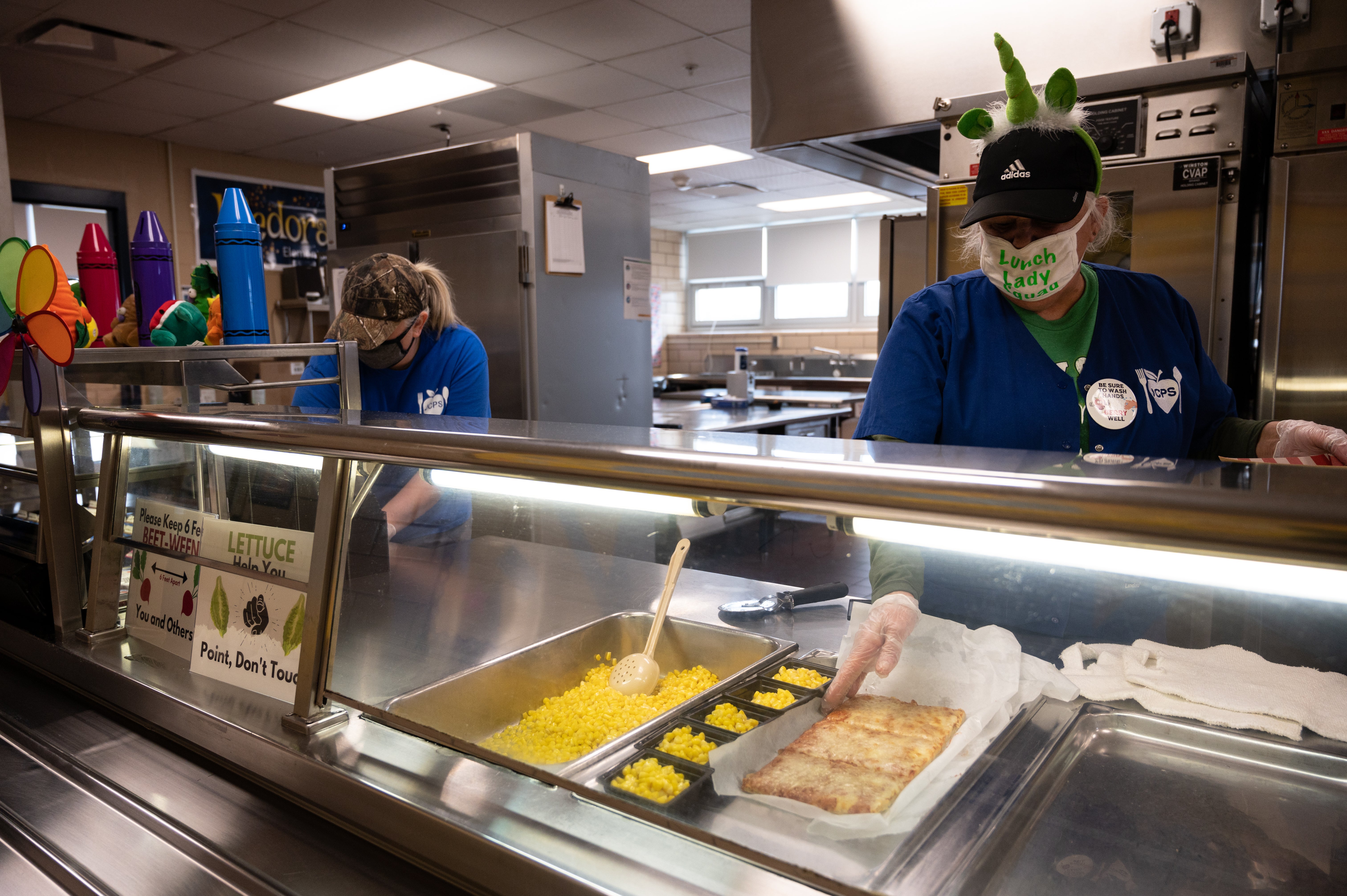 The virus is still out there, but rates of test positivity, hospitalizations, and emergency department visits are all down. Pictured: School lunch workers as class resumed in-person learning in 2021