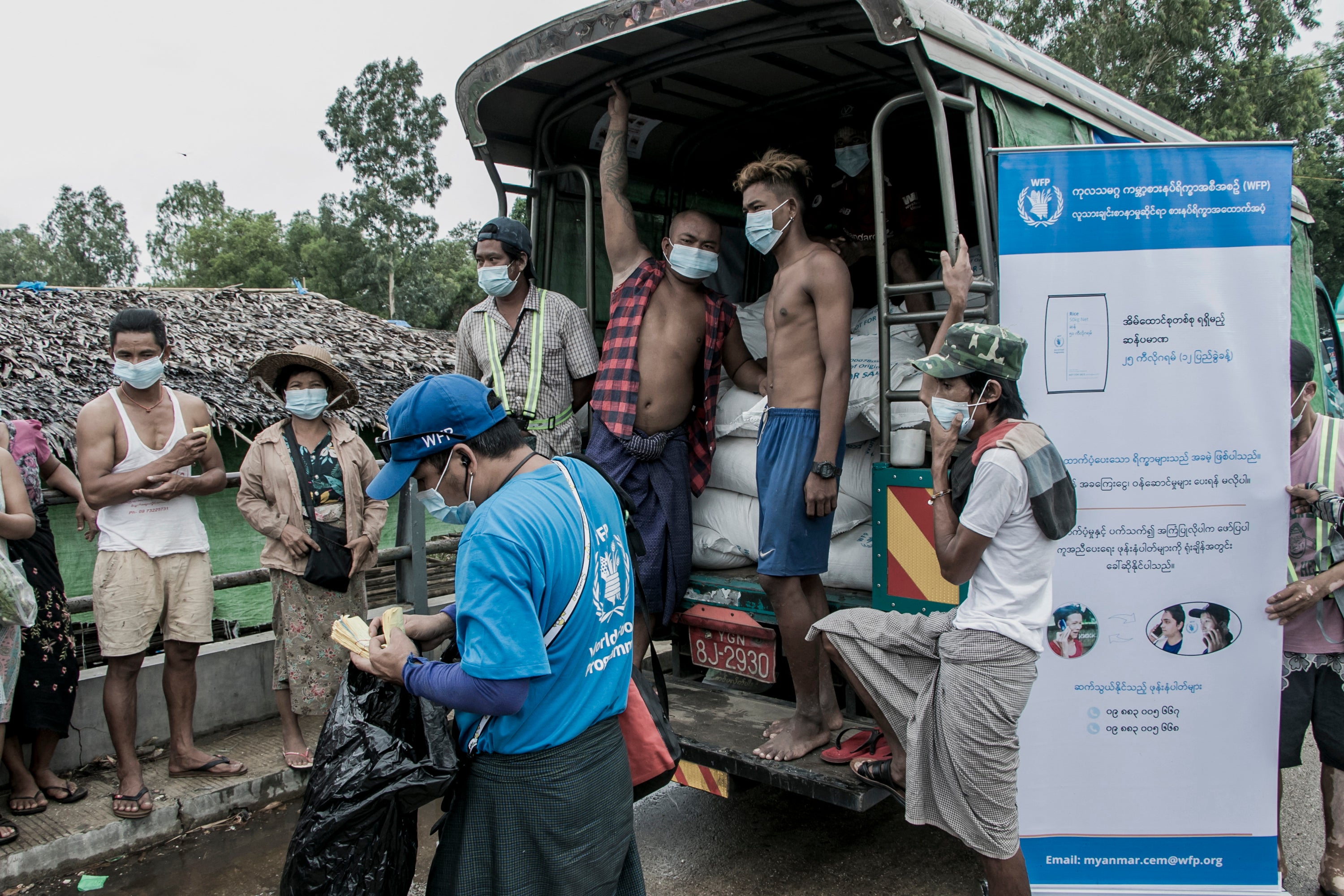 File: People wait to receive bags of rice distributed by the World Food Programme on the outskirts of Yangon in 2021