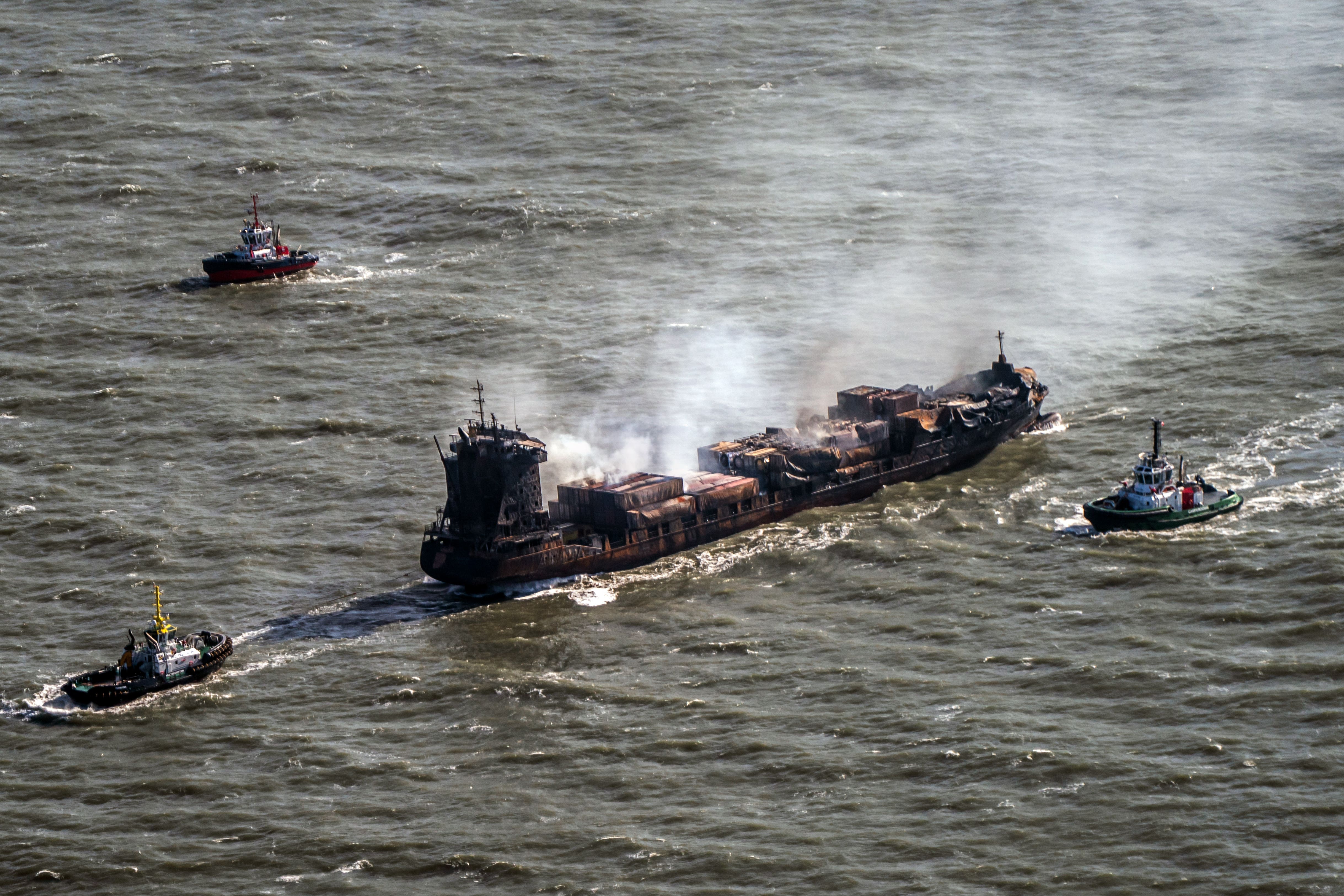 Tug boats shadow the Solong container ship as it drifts in the Humber Estuary following a collision with the MV Stena Immaculate oil tanker (Danny Lawson/PA)