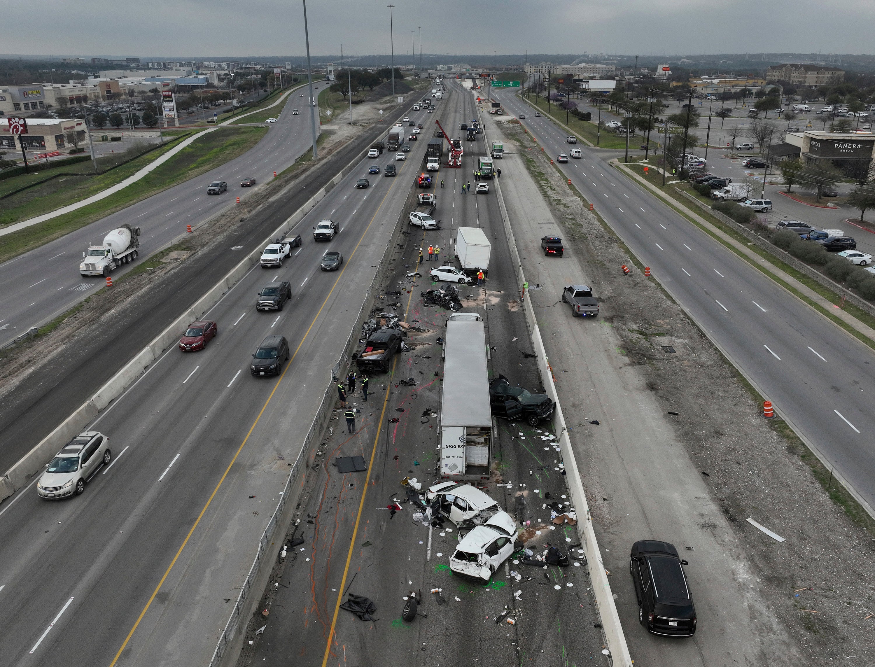 Officials examine the aftermath of a fatal crash on I-35 southbound near Parmer Lane