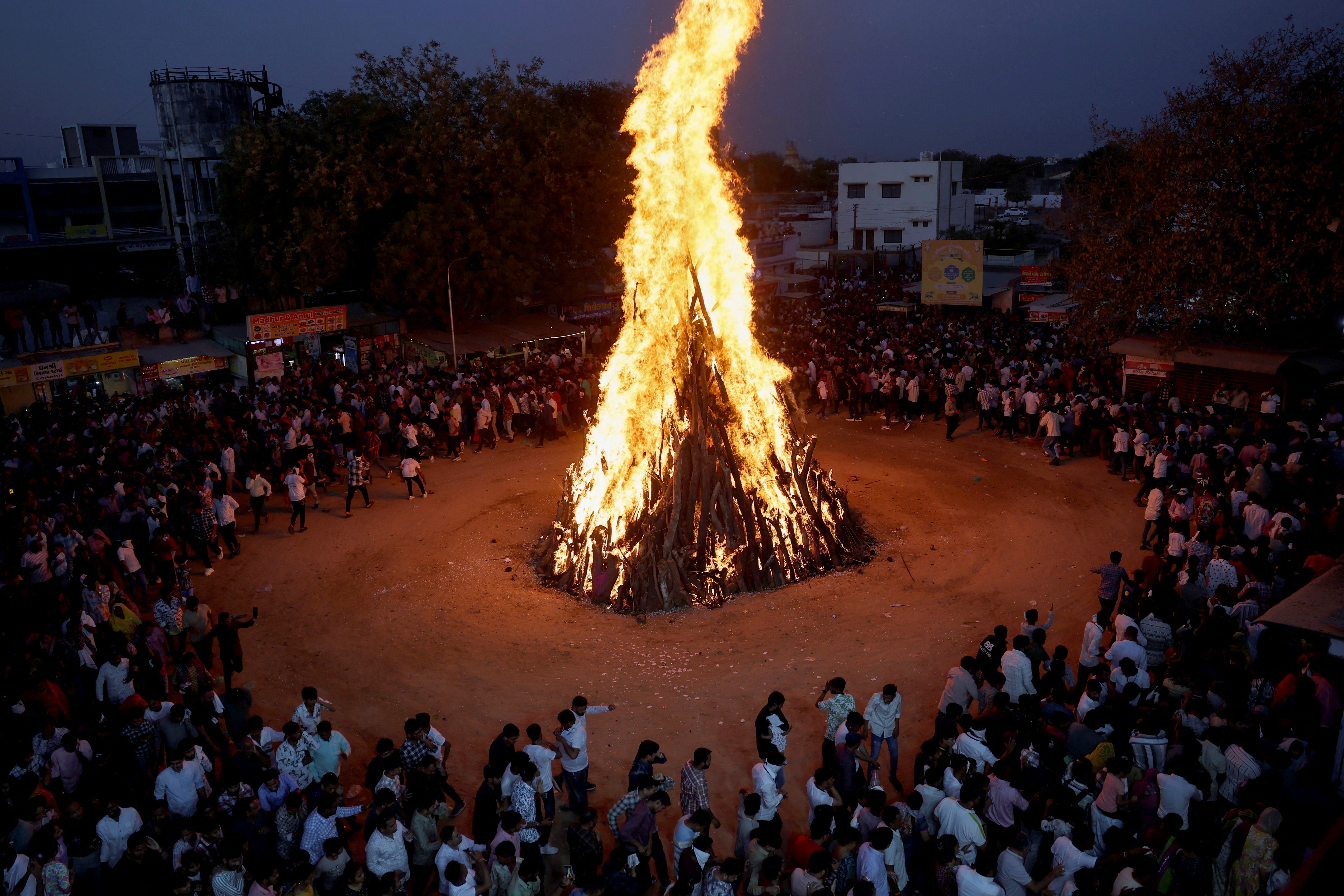 Hindu devotees walk around a bonfire during a ritual known as 'Holika Dahan' on the outskirts of the western city of Ahmedabad