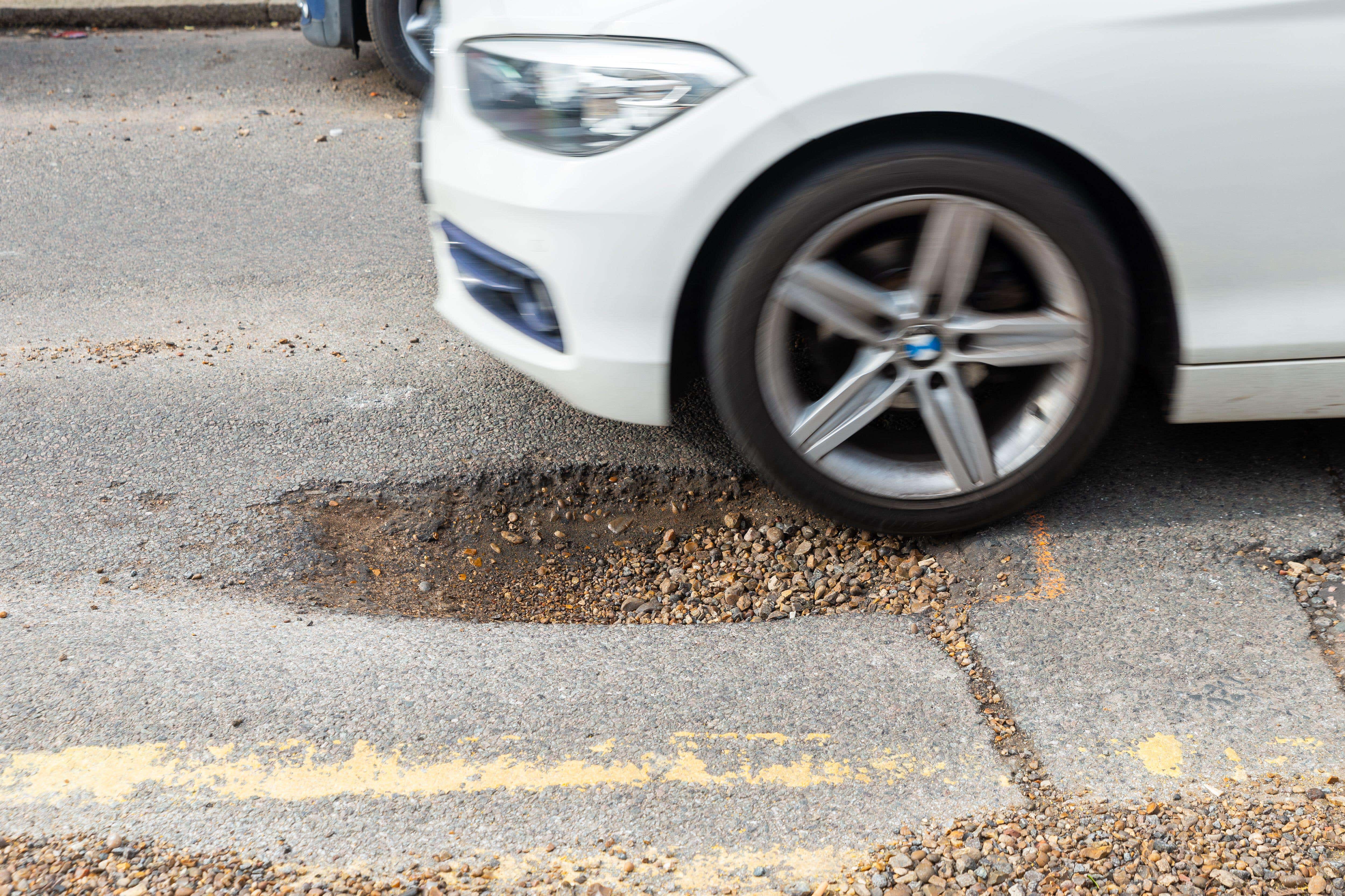 The cost of bringing pothole-plagued local roads in England and Wales up to scratch has been estimated at a record high of nearly £17 billion (Alamy/PA)