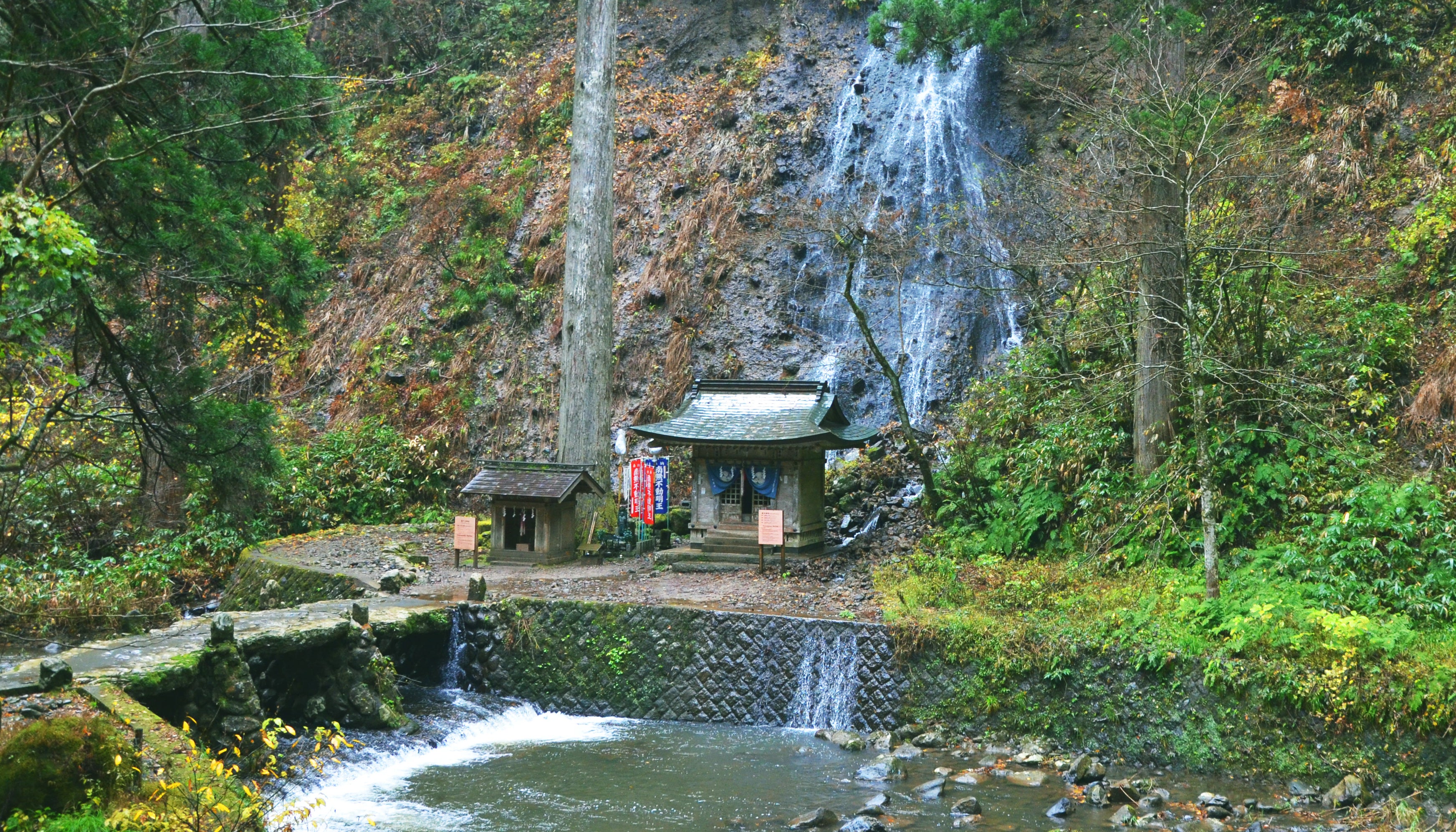 A shrine next to a waterfall at Haguro Mountain