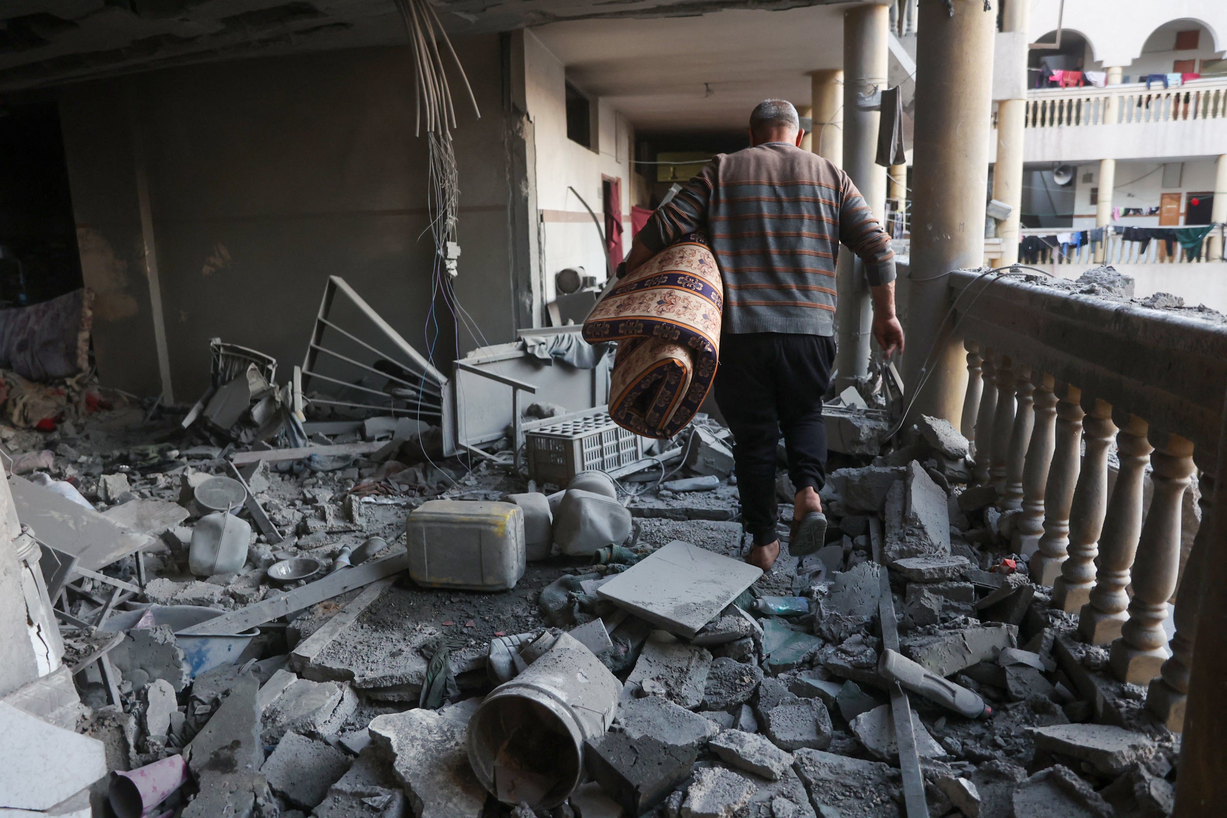 A man treads through rubble in Gaza City as the ceasefire between Hamas and Israel is broken