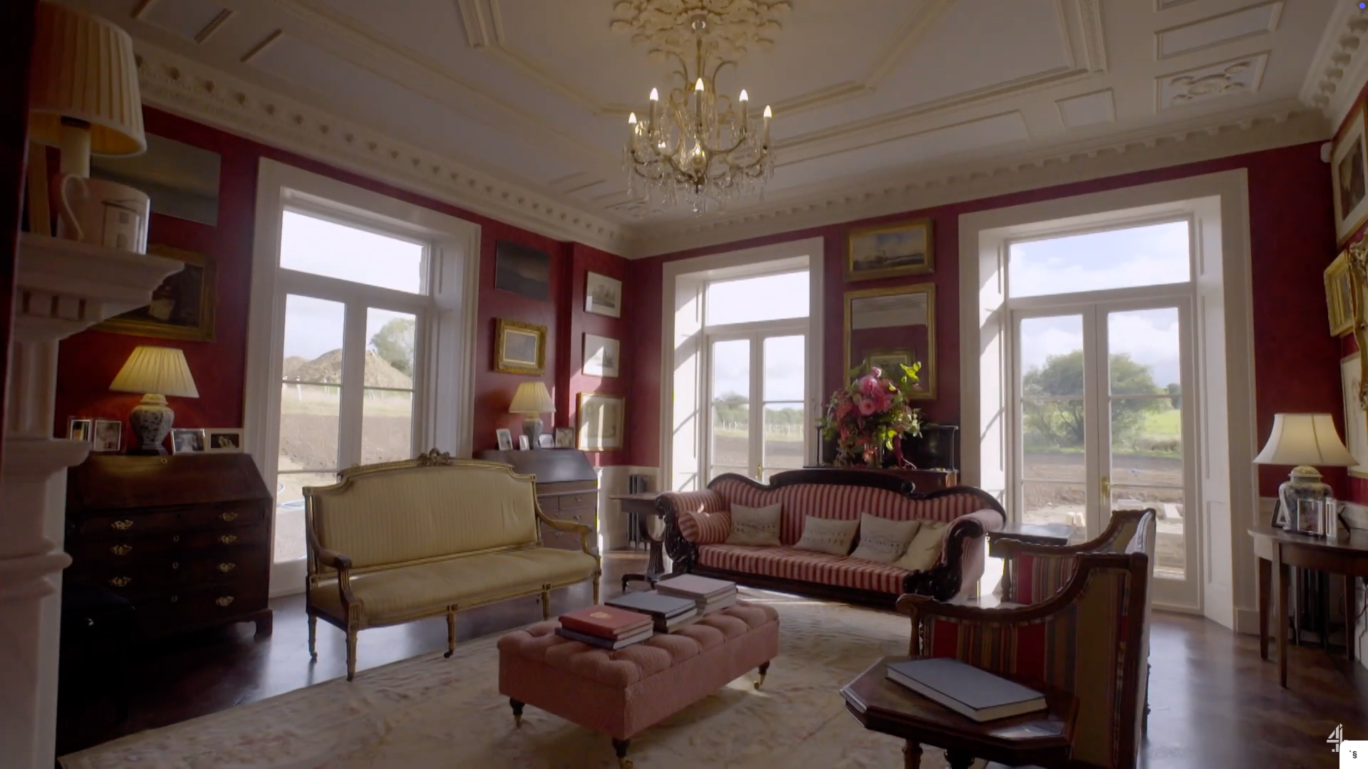 The dining room features high ceilings and dark red wallpaper