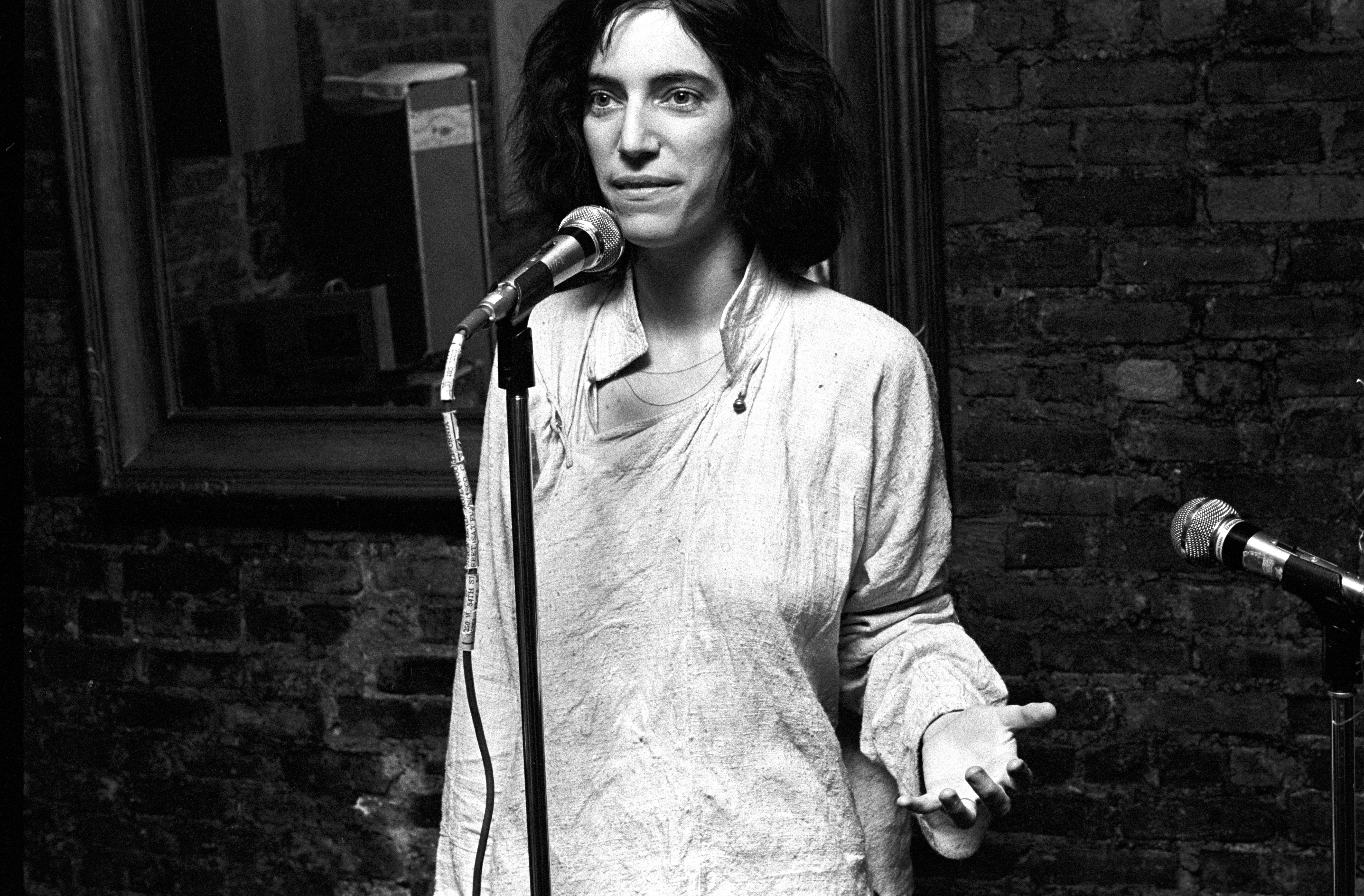 Patti Smith reciting poetry on stage at the club Local in New York City, 1975