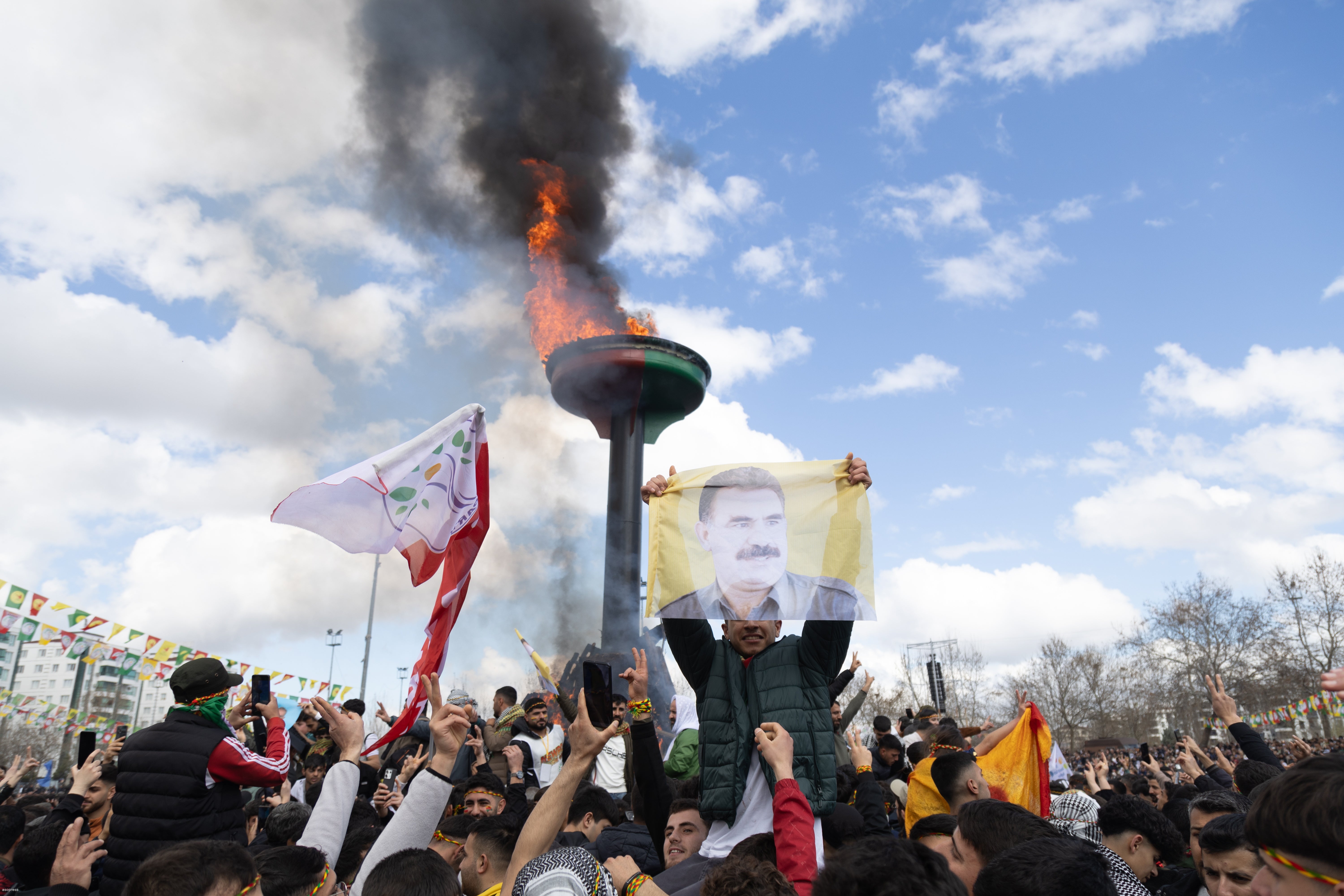 Supporters of The Peoples' Equality and Democracy Party (DEM) hold pictures of Kurdistan Workers' Party (PKK) jailed leader Abdullah Ocalan, and shout slogans next to a bonfire during a rally for Newruz celebrations in Diyarbakir, Turkey, 21 March 2025