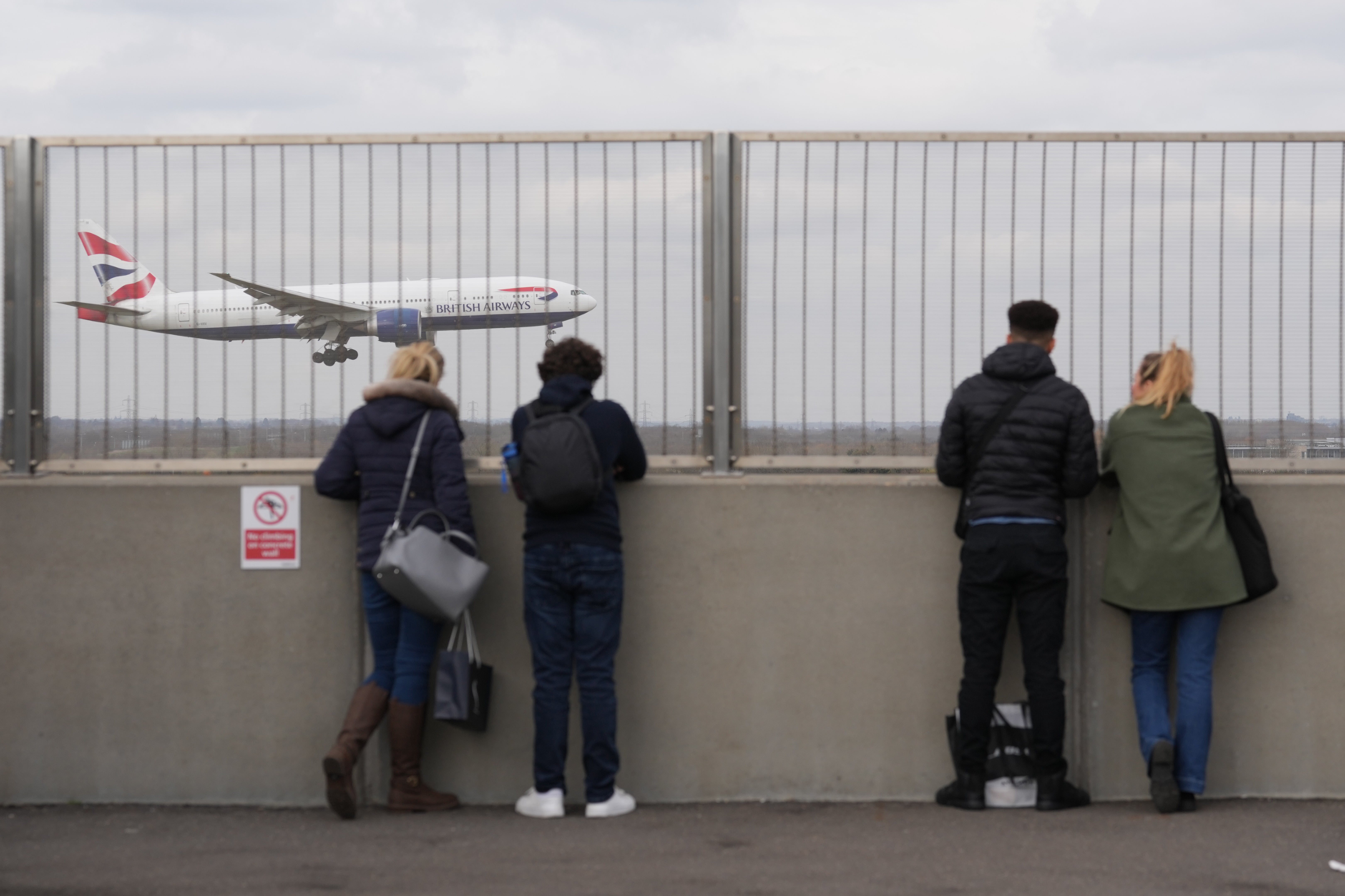 People watch a British Airways plane at Heathrow airport in London