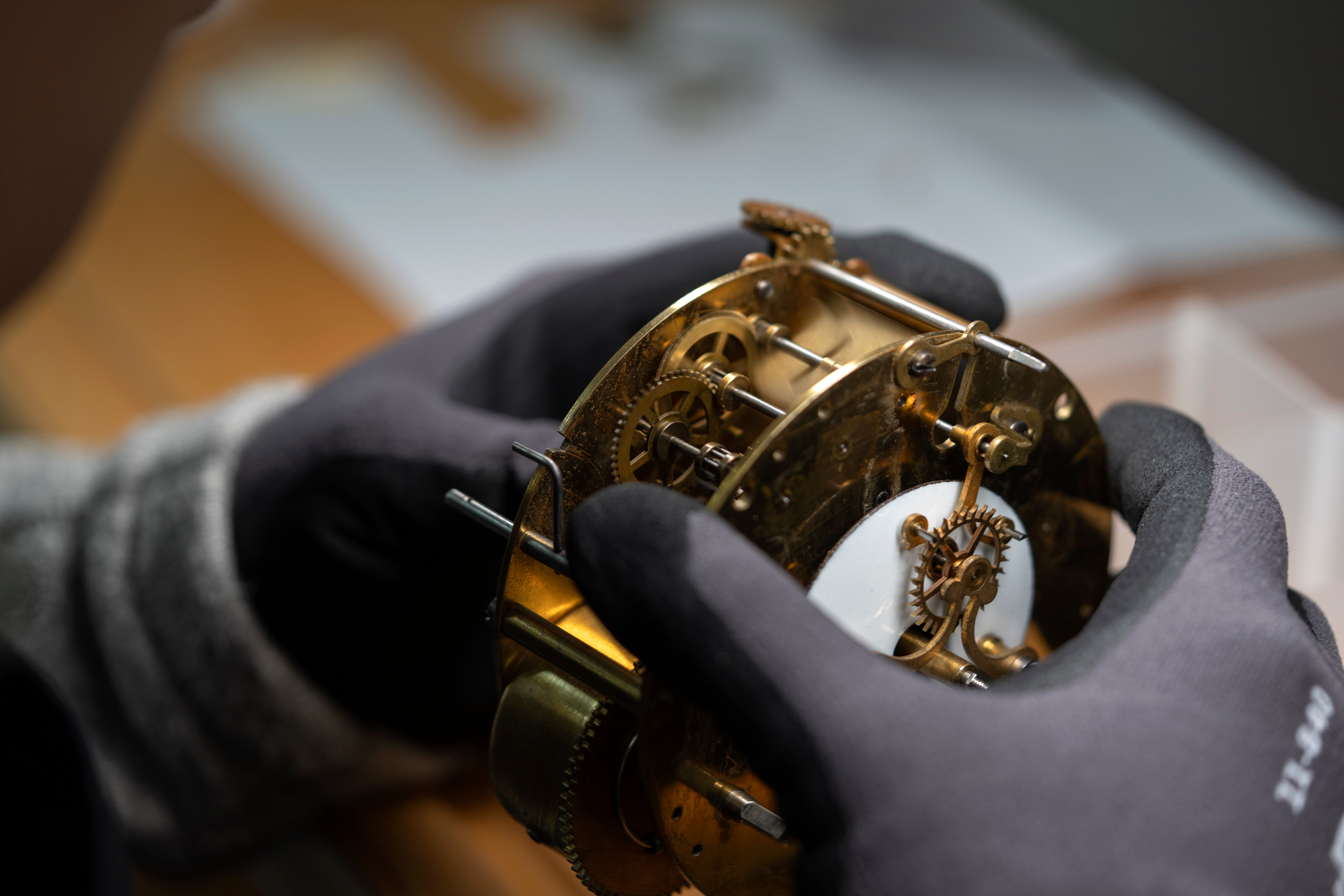 A restorer works on the mechanism of an antique clock