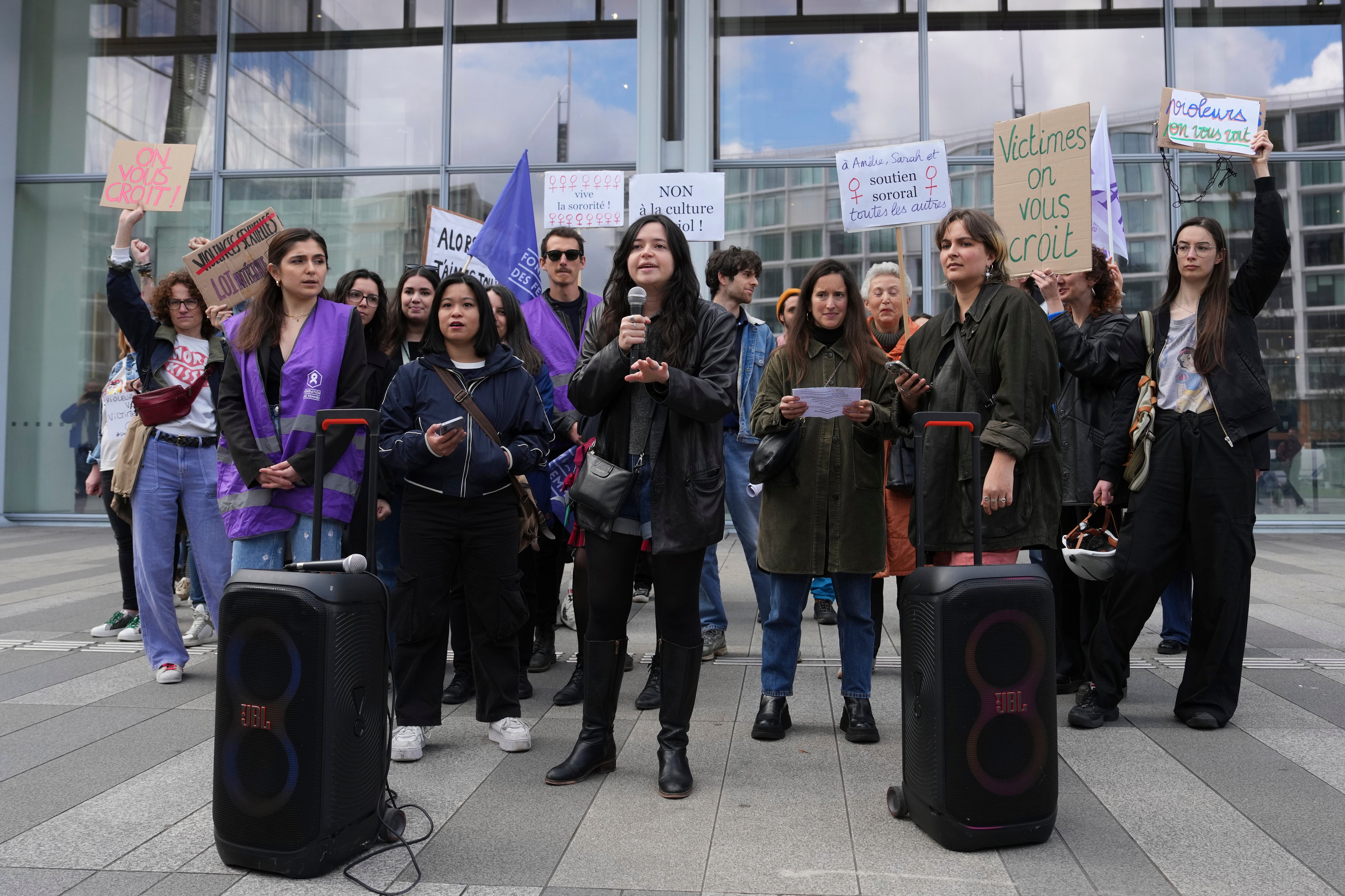 Women demonstrate outside the Palais de Justice in Paris, where Depardieu faces trial