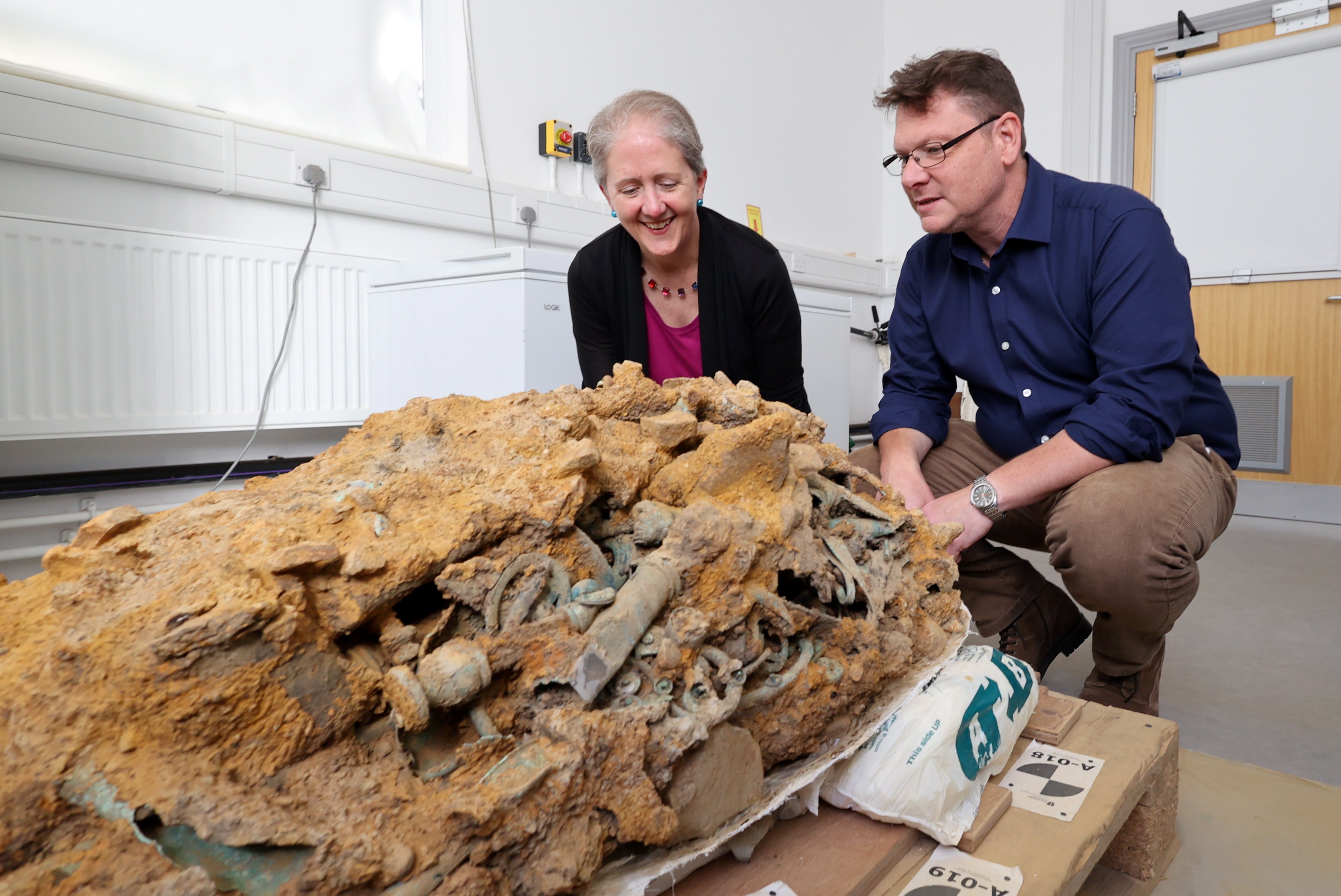 Dr Emily Williams and Professor Tom Moore, of the Department of Archaeology, Durham University, examining the block of tangled Iron Age artefacts corroded together in the hoard