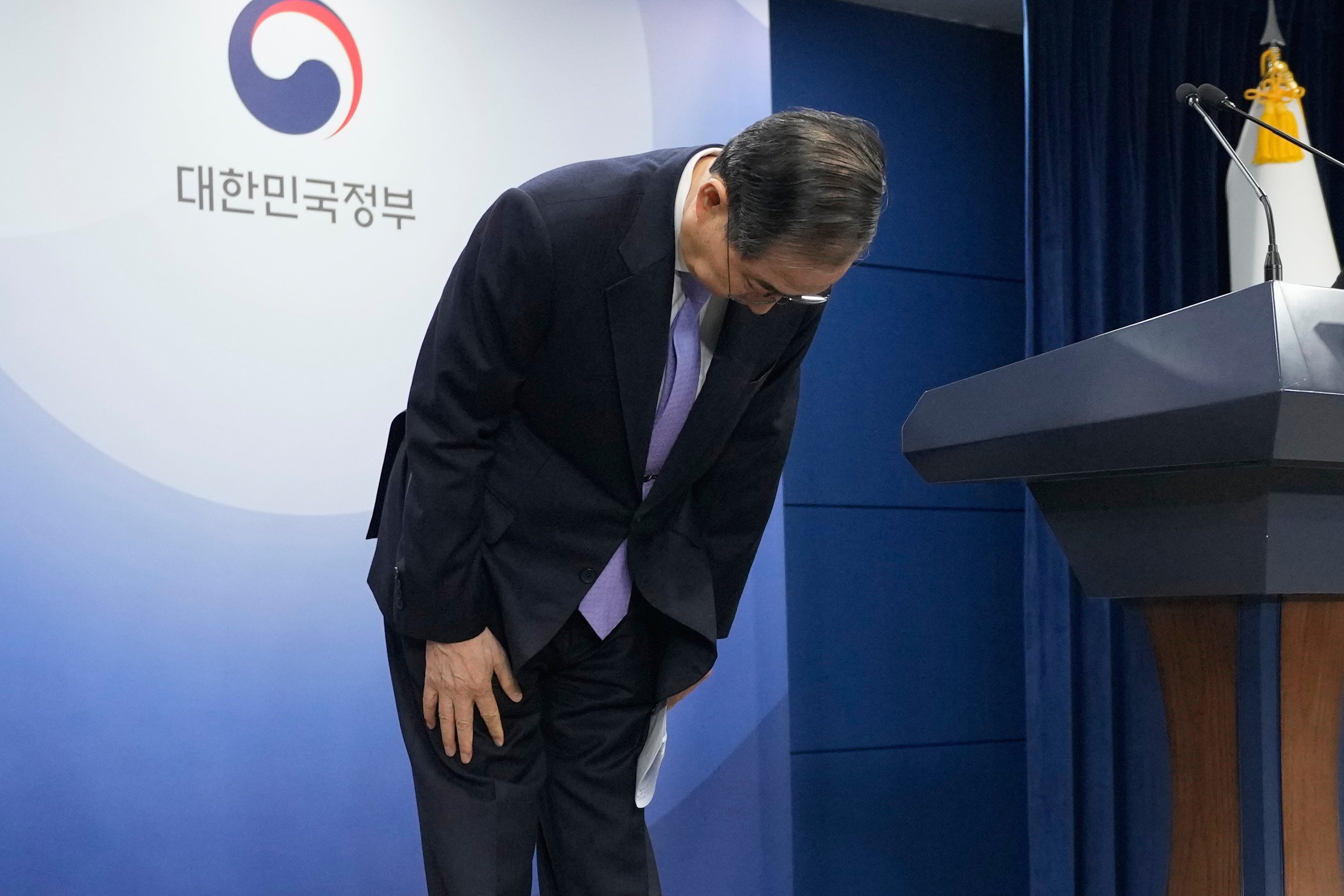 South Korean acting President Han Duck Soo, who also serves as prime minister, bows during a briefing at the Government Complex in Seoul