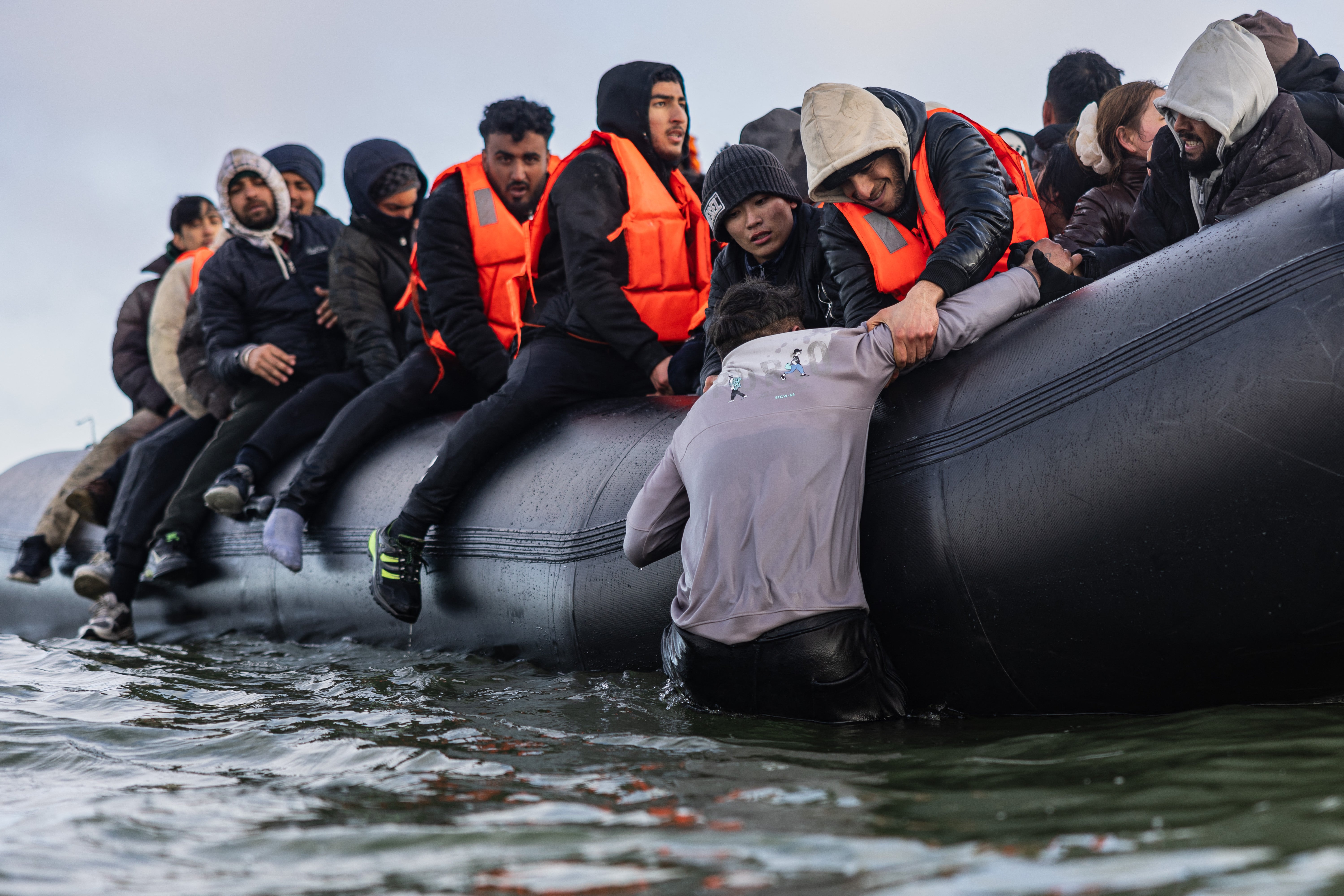Migrants board a smuggler’s boat in an attempt to cross the English Channel from France