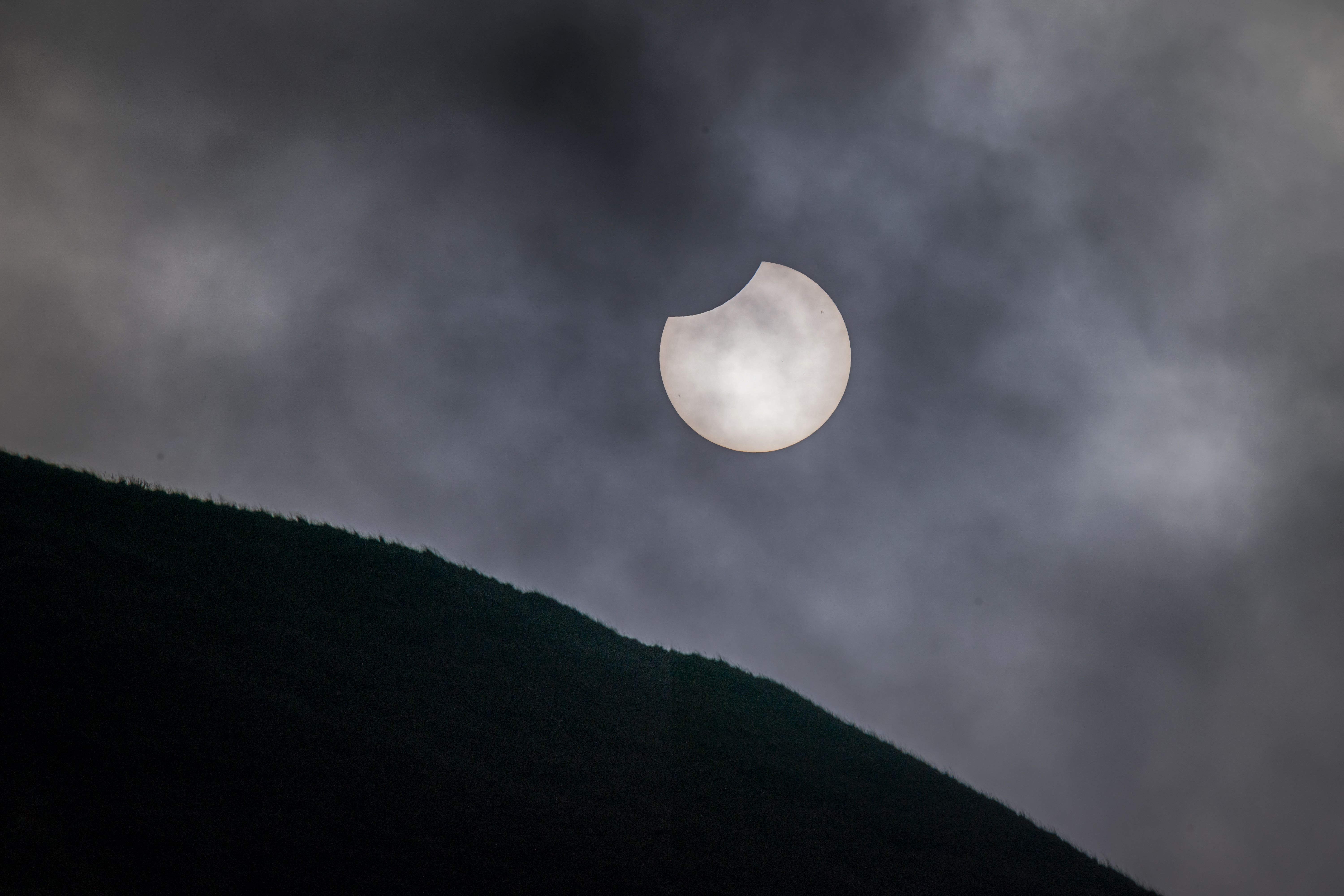 The sun breaks through clouds at during a partial solar eclipse in 2022 (Danny Lawson/PA)