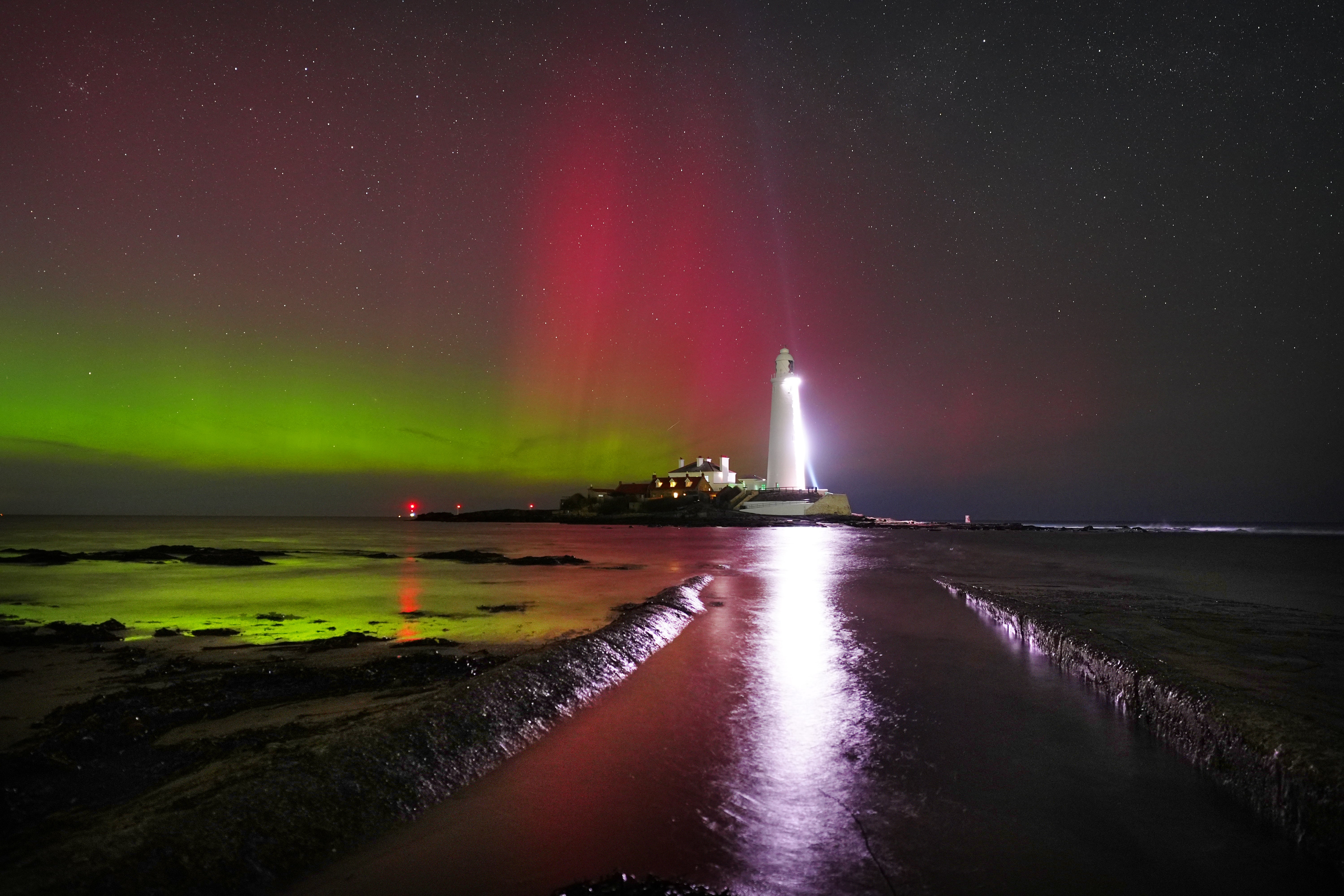 The sky is filled with colour from the aurora borealis at St Mary's lighthouse in Whitley Bay