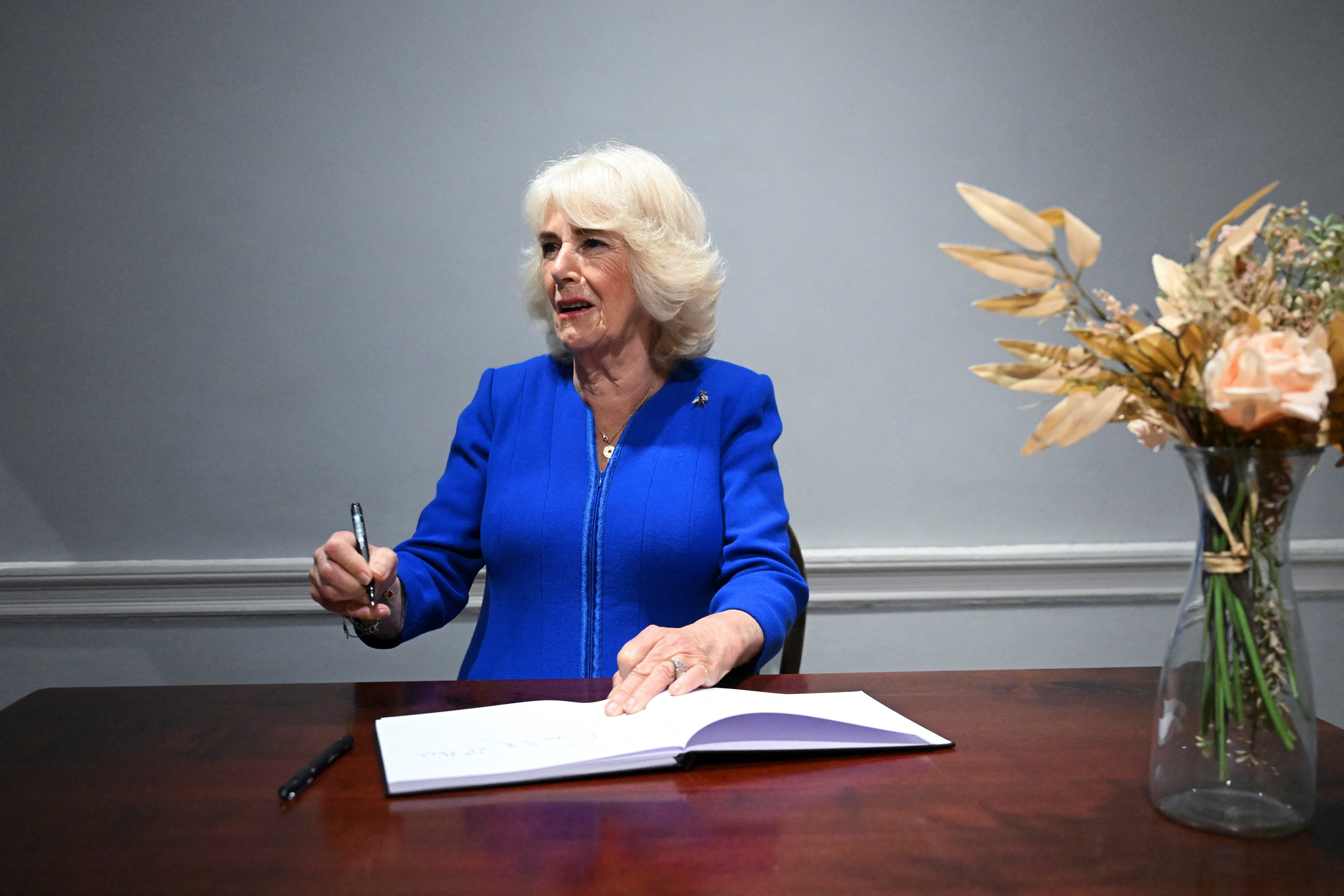 Queen Camilla signs the guest book during her visit to Charles Dickens House Museum in London to celebrate 100 years since the house was opened to the public (Jaimi Joy/PA)