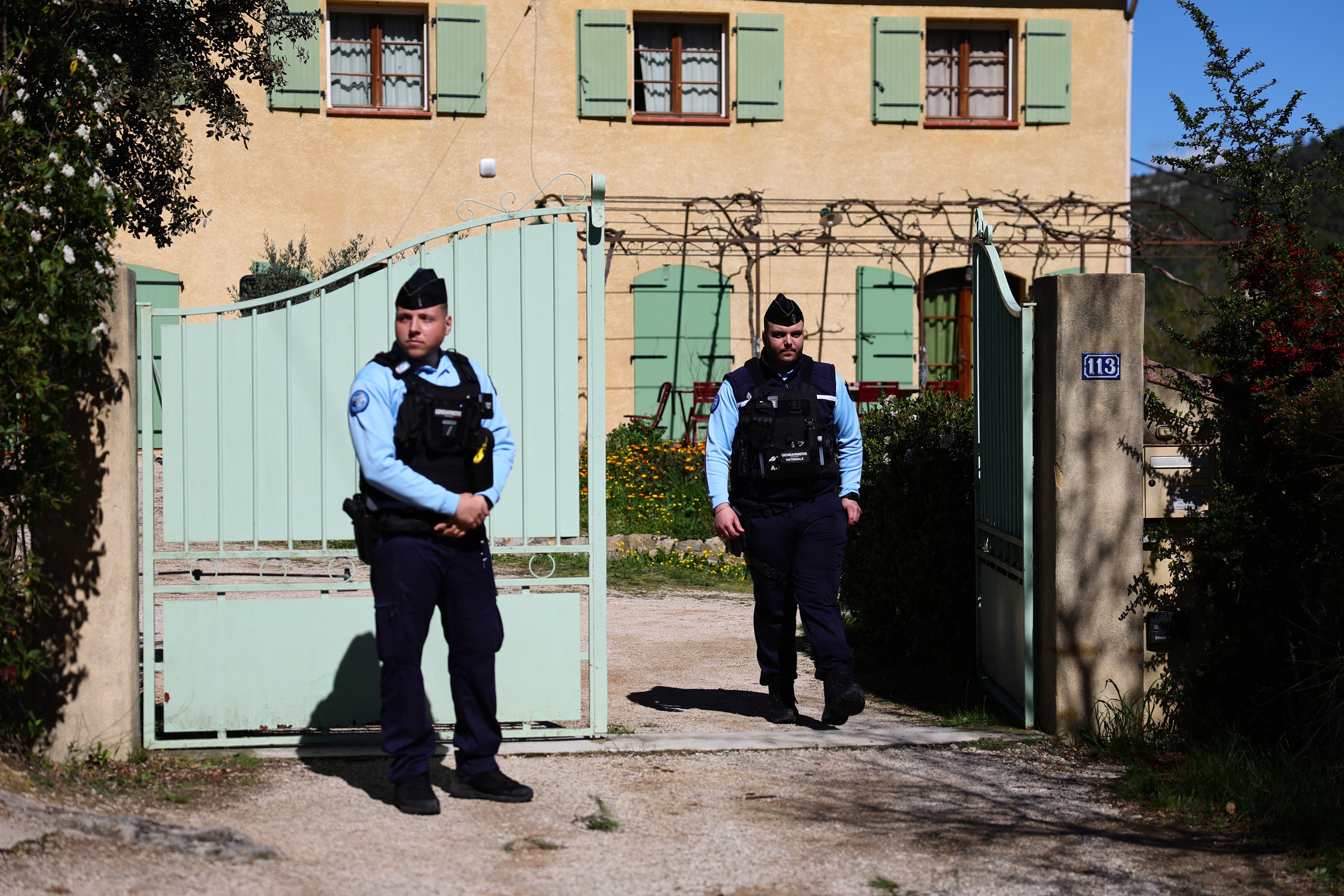 Gendarmes guard the entrance to the family’s property after a dawn raid on Tuesday