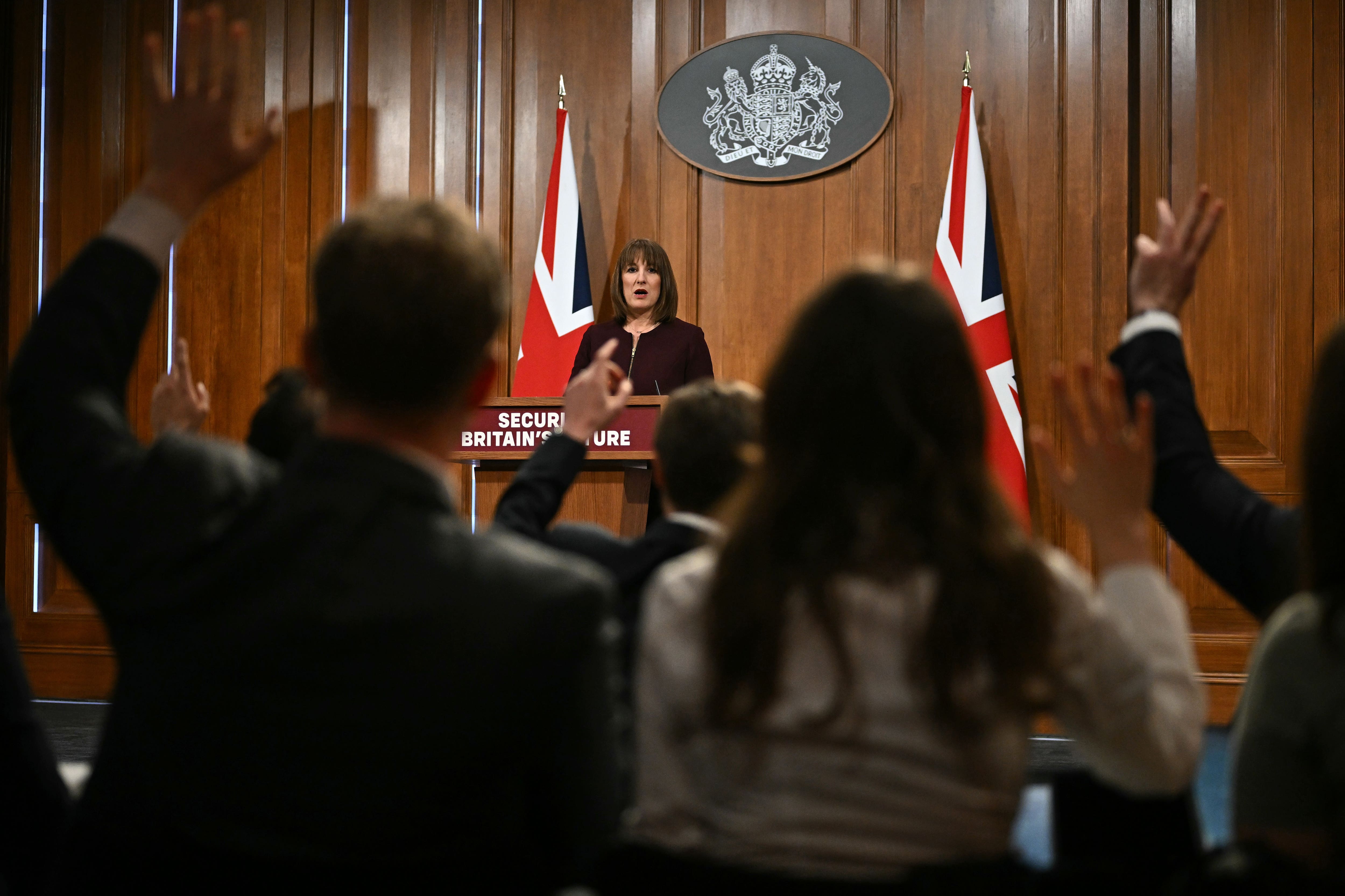 Rachel Reeves at a lectern answering questions, with members of the media in the foreground (Ben Stansall/PA)