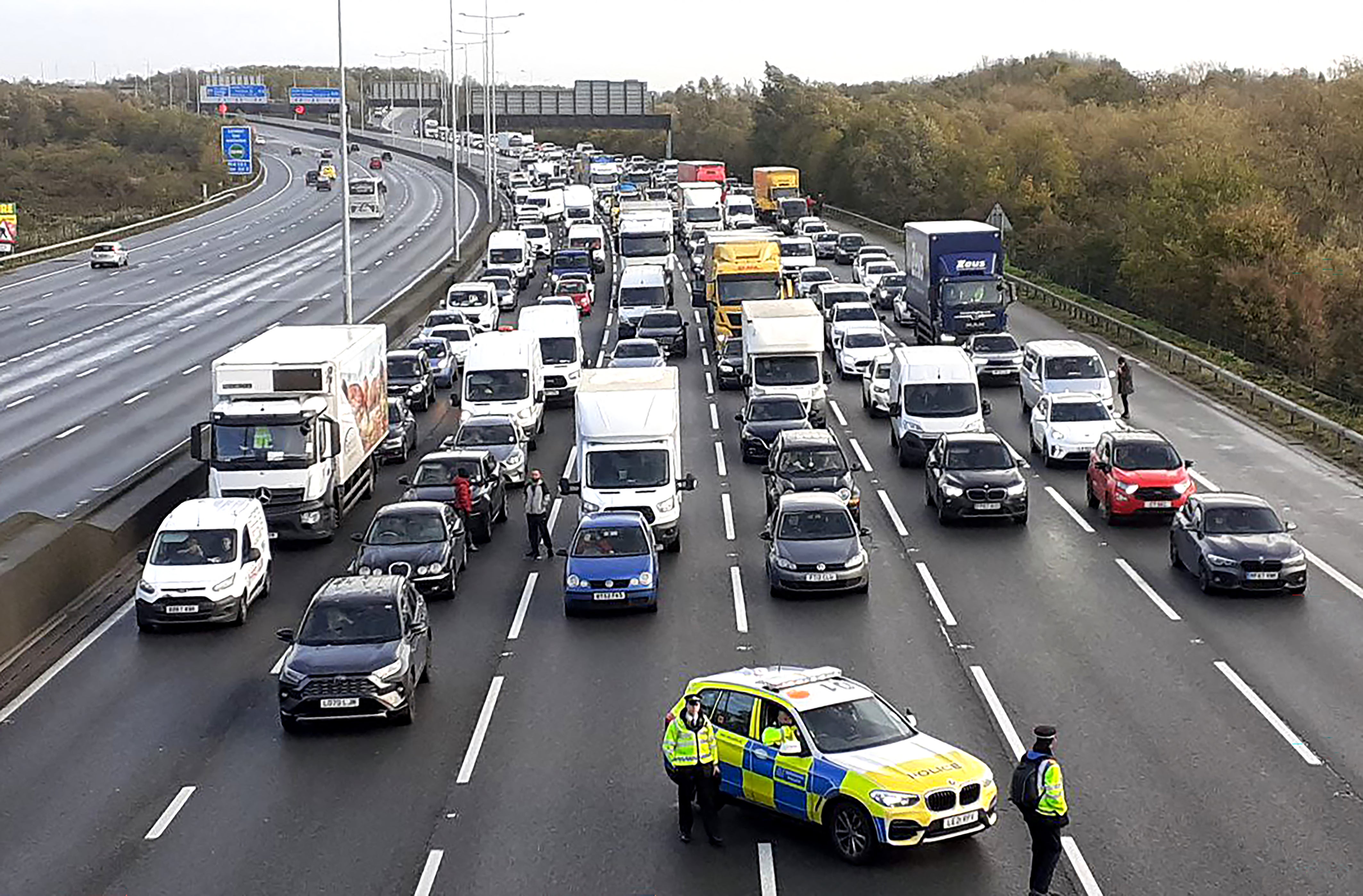 Police closing the M25, where a demonstrator from Just Stop Oil climbed the gantry in 2022 (Just Stop Oil/PA)