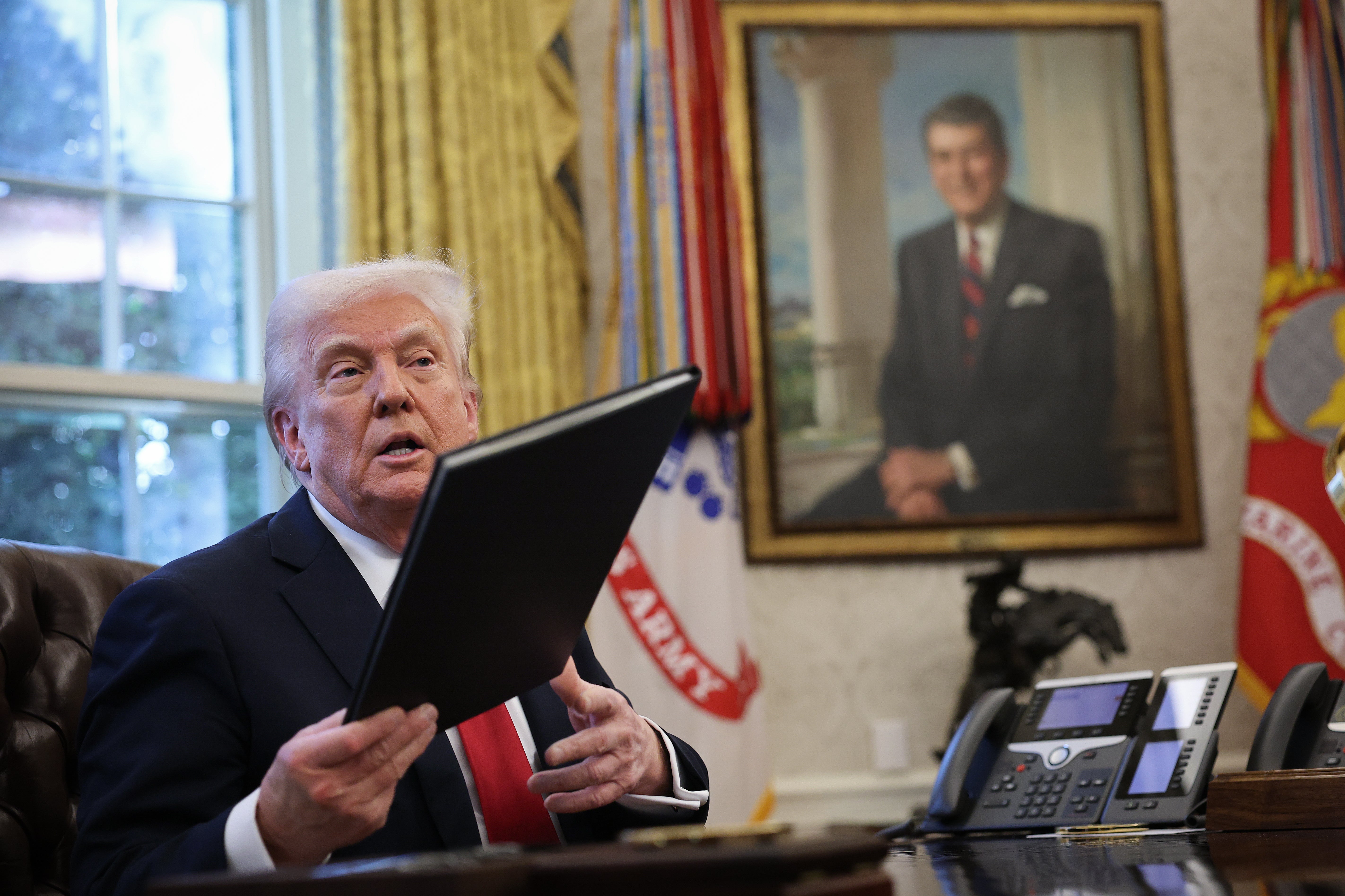 President Donald Trump talks with members of the press after signing an executive order in the Oval Office. Trump announced 25 percent tariffs on all foreign-made cars.