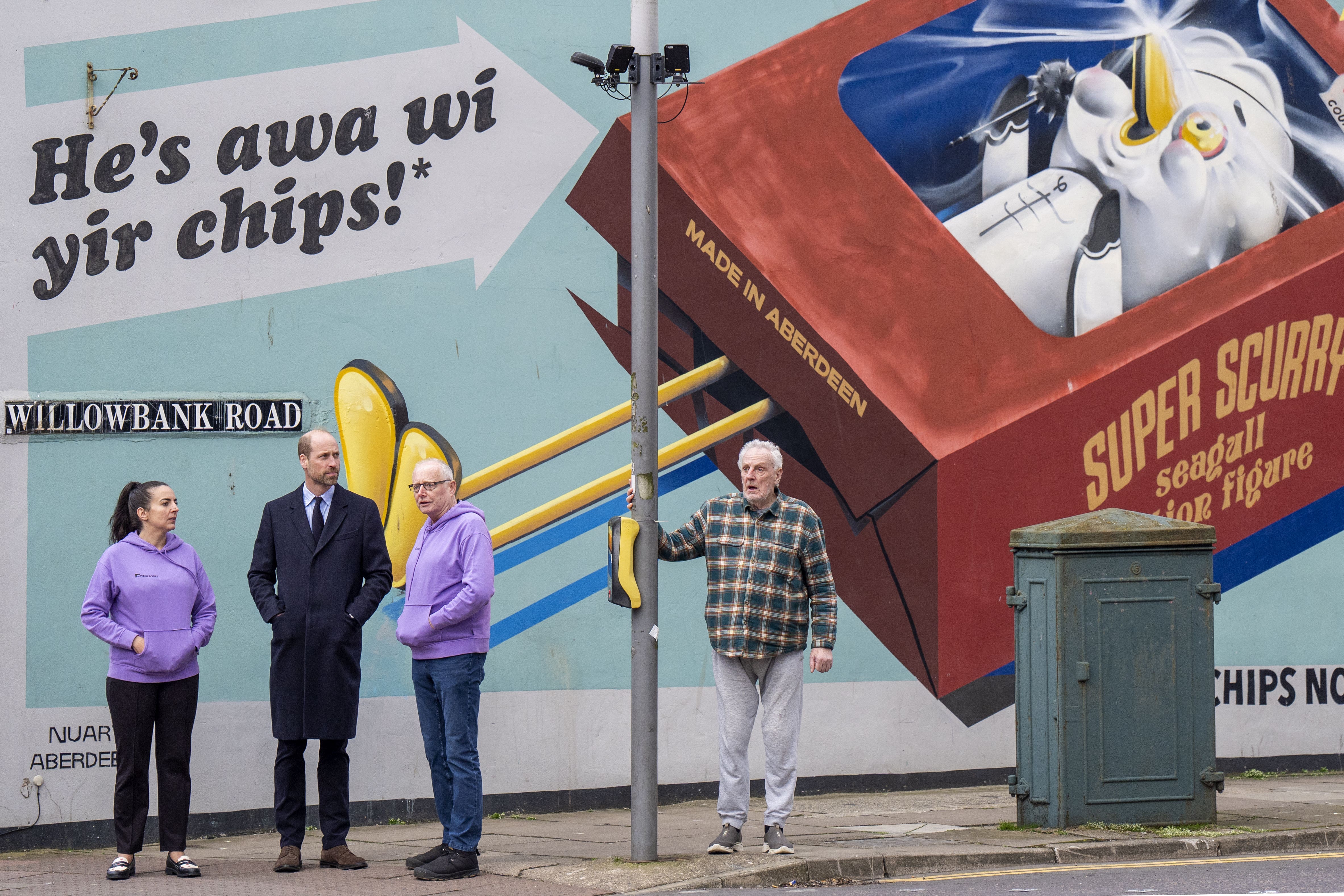 The Prince of Wales with volunteer guides on a street corner in Aberdeen (Jane Barlow/PA)