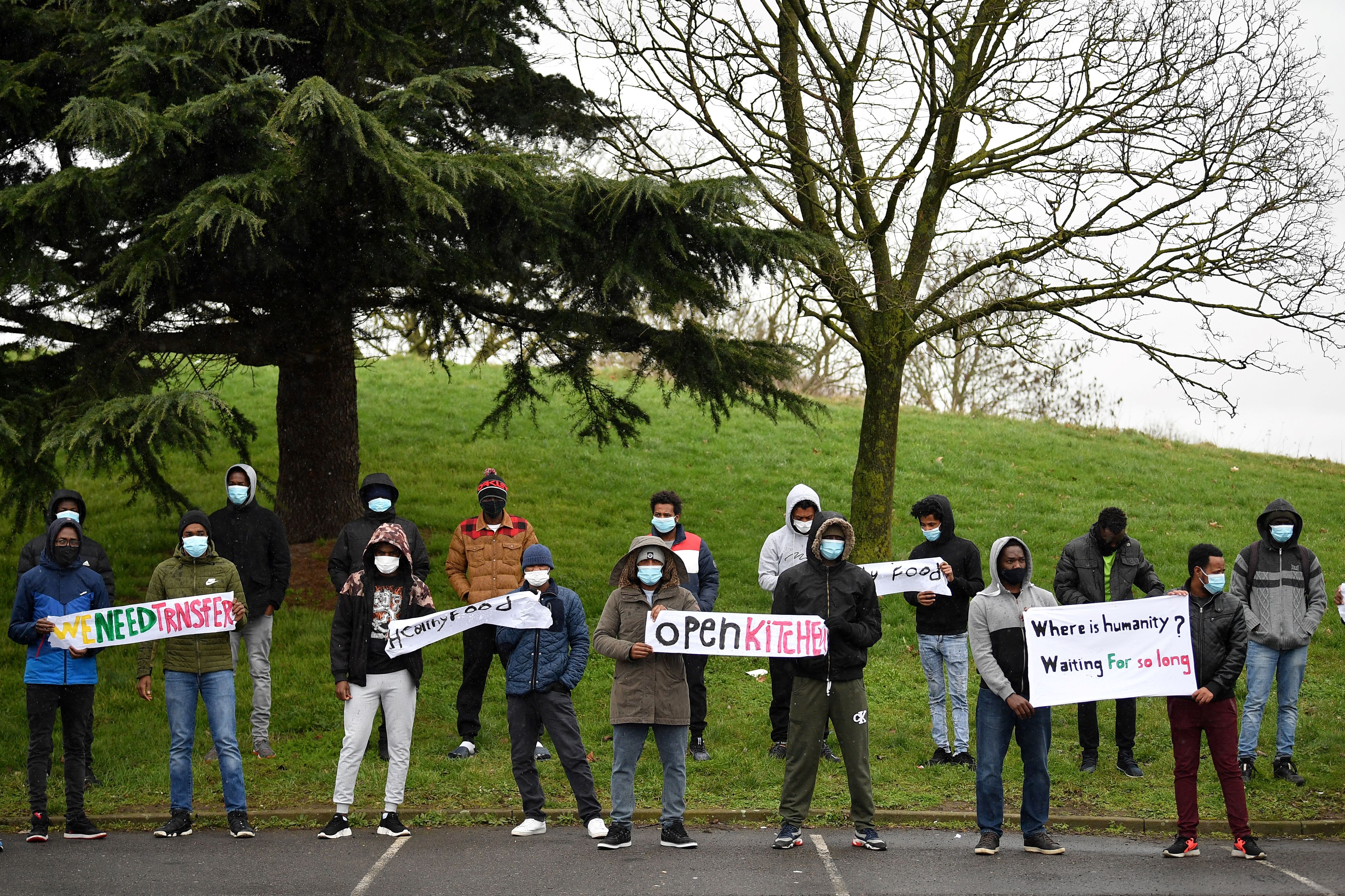 Asylum seekers protest their living conditions and the length of time the claims process is taking, outside a hotel in west London, on February 16, 2021.