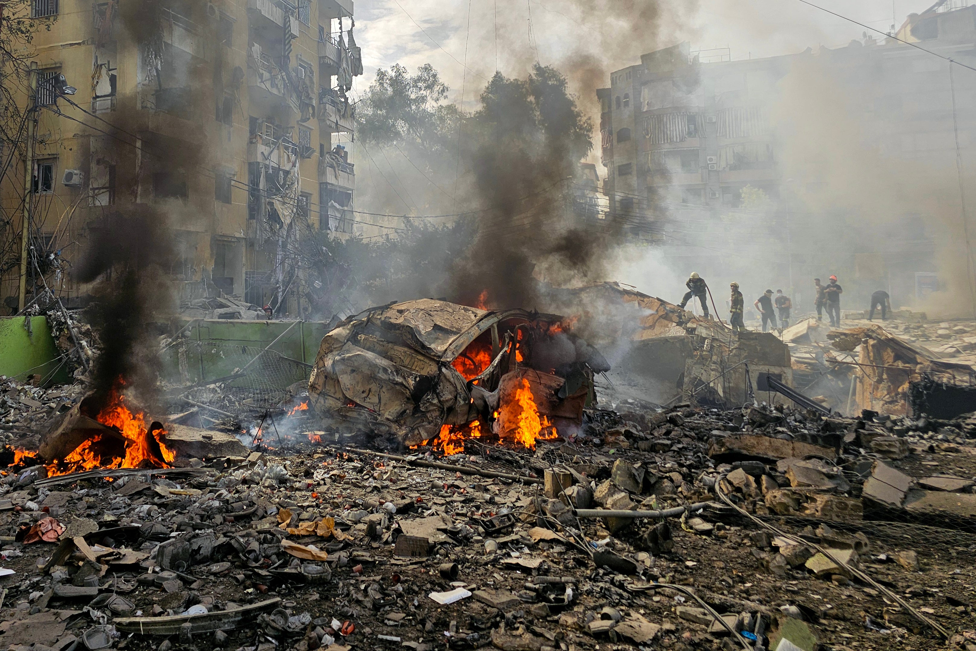 A firefighter sprays water on the debris following the strike