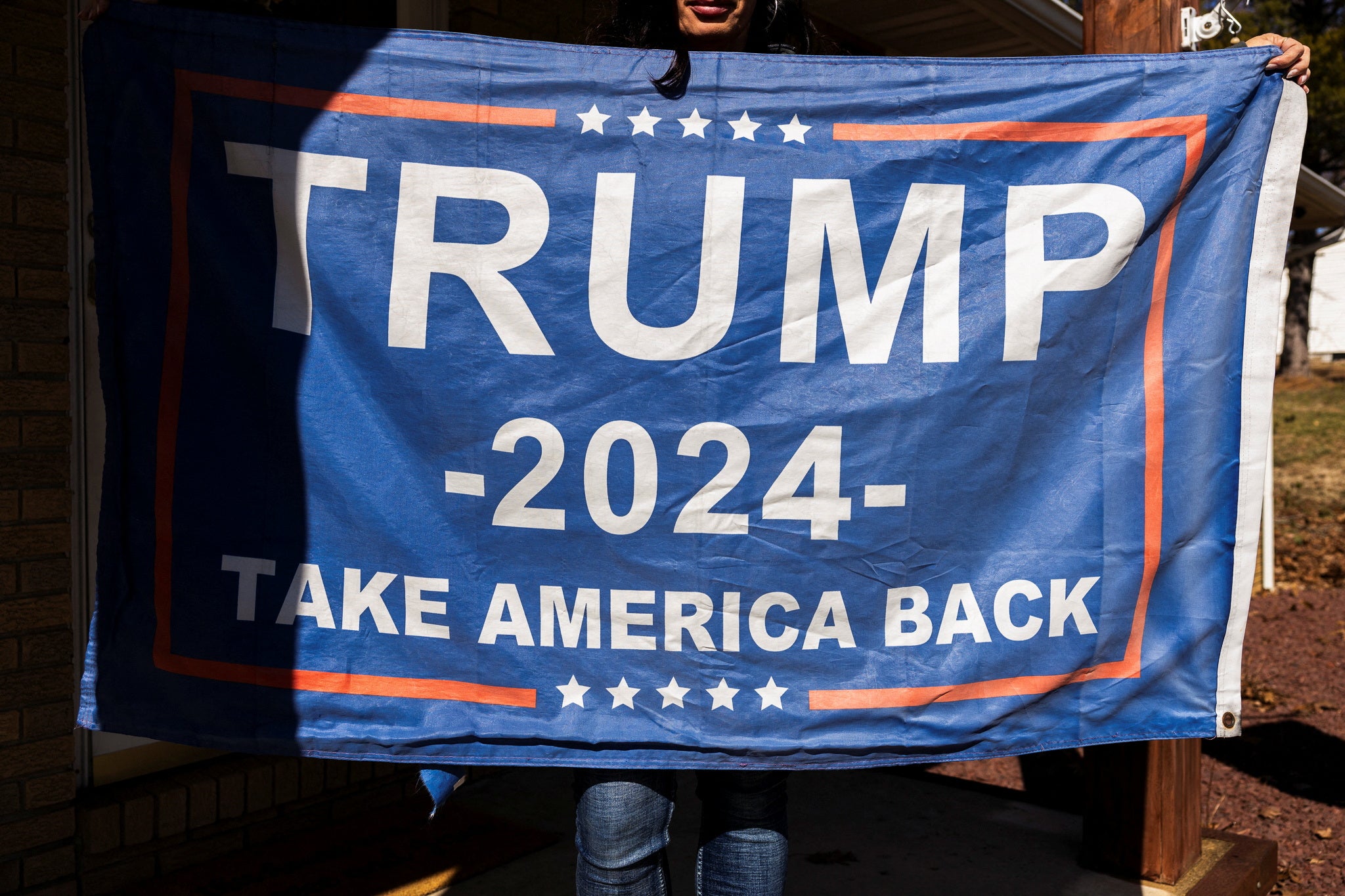 Piggott holds a Trump flag. She says she was fired despite receiving the highest rating possible on her performance review