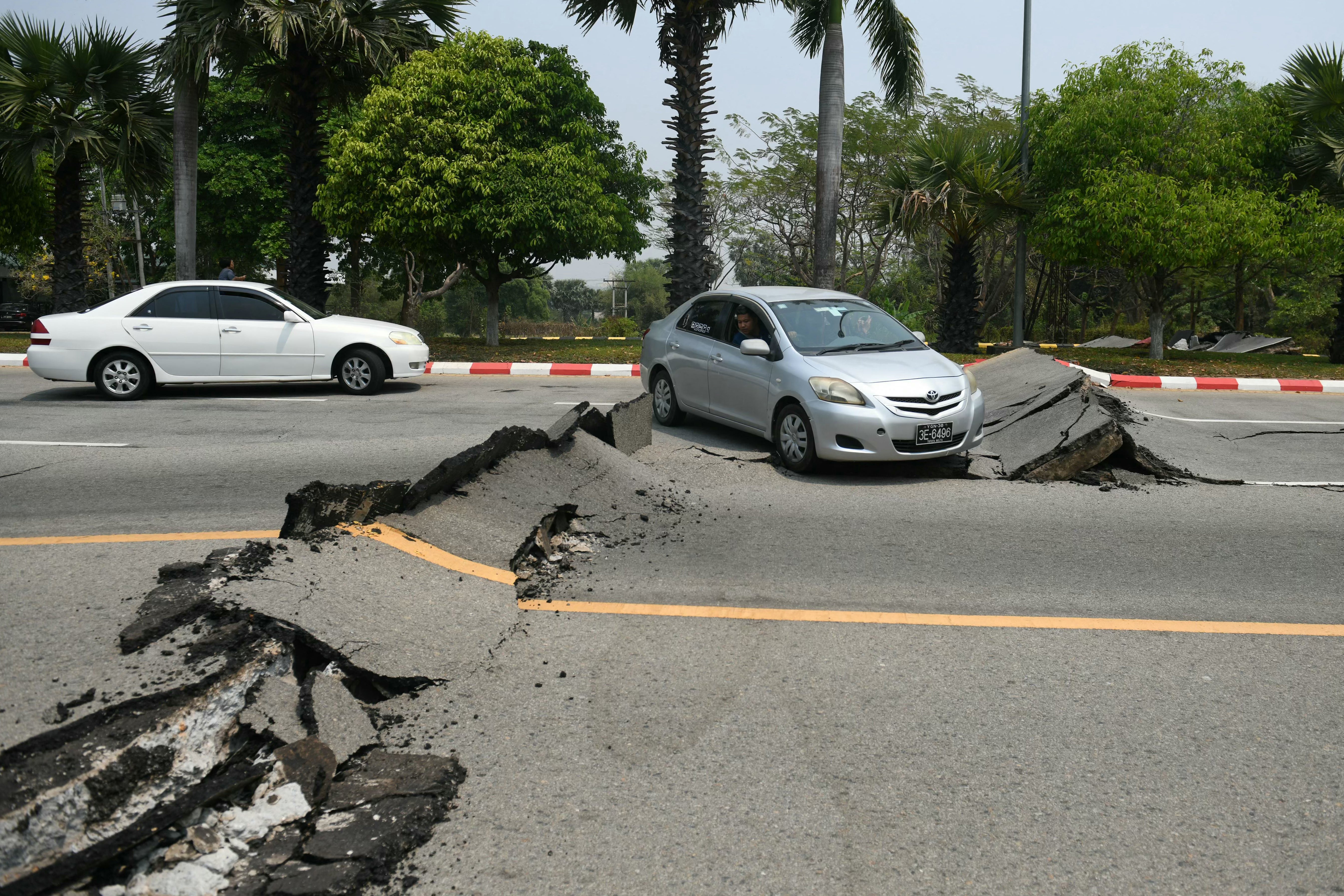Cars pass a damaged road in Naypyidaw