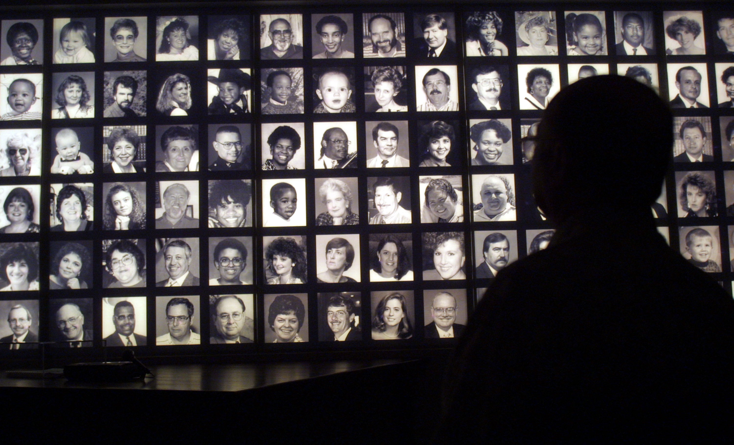 A visitor looks at the faces of some of the victims of the Oklahoma City bombing at the Oklahoma National Memorial museum in Oklahoma City June 12, 2001, one day after the execution of Timothy McVeigh.