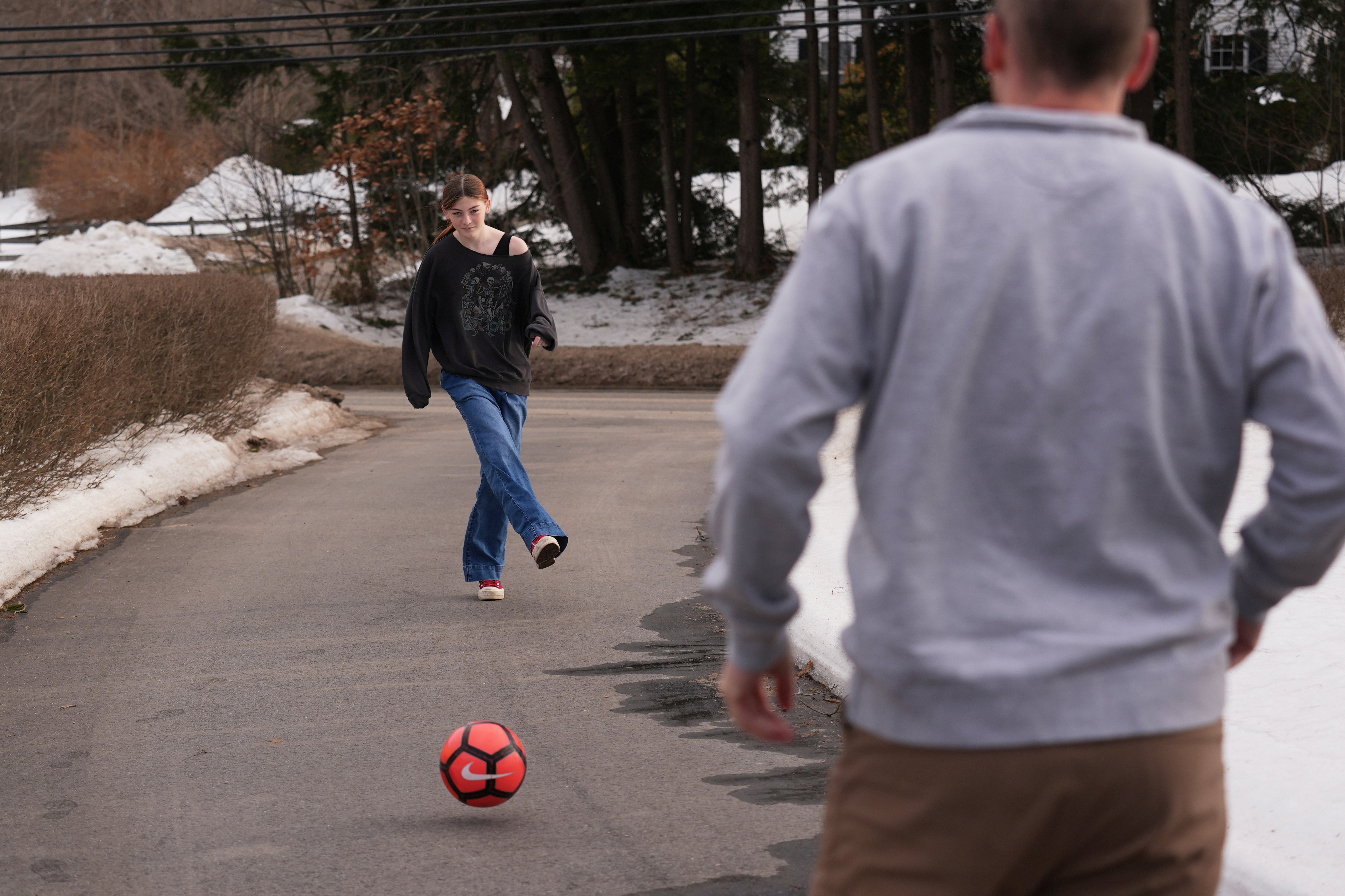 Parker Tirrell, a transgender athlete who plays on her high school's girls soccer team, practices with her Dad in the driveway of their family home, Friday, March 7, 2025, in Plymouth, N.H. (AP Photo/Charles Krupa)